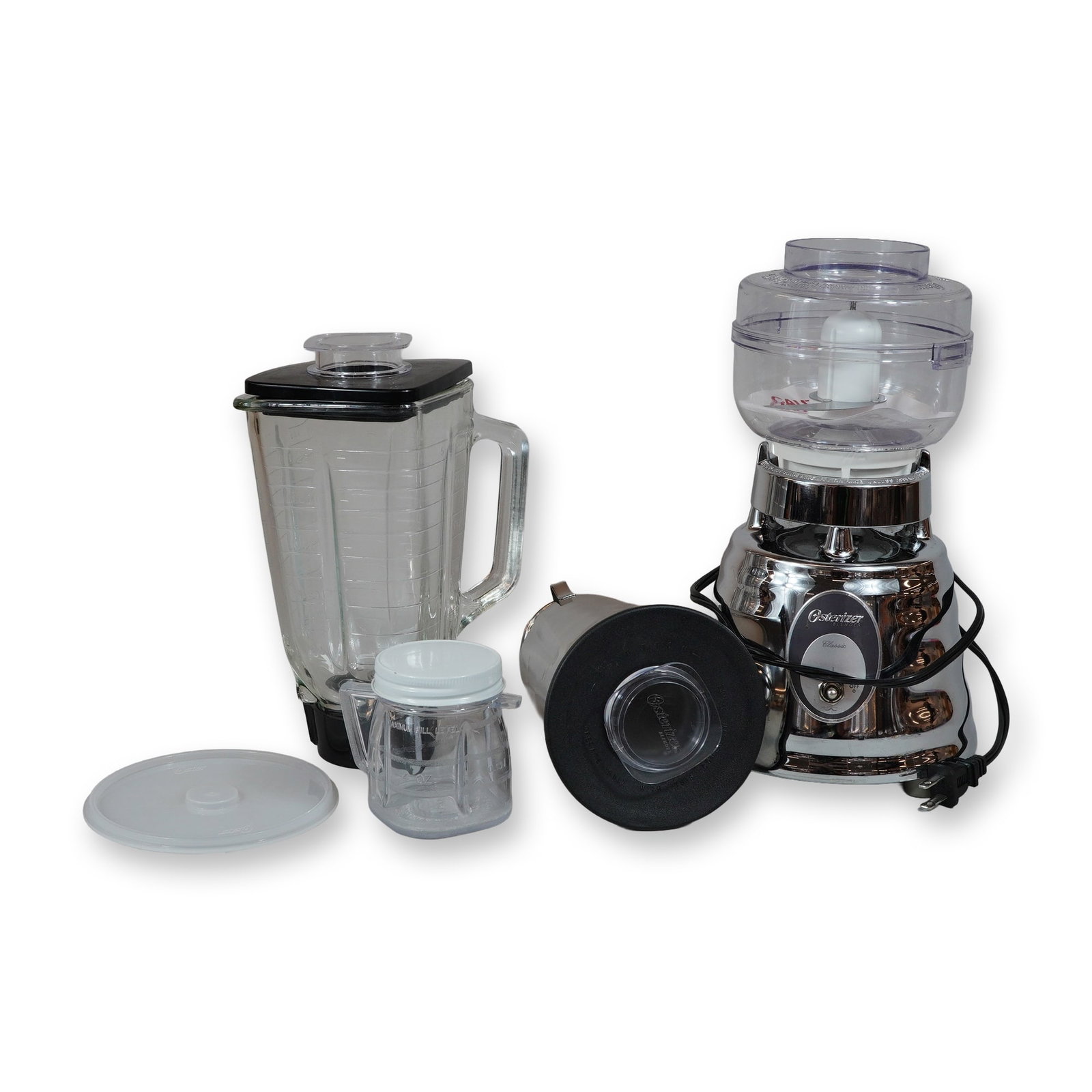 Osterizer Classic Chrome Beehive Blender Set: Osterizer Classic beehive blender set featuring a motor base with a polished chrome-plated finish, Service No. 4094. The collection includes a square glass pitcher with a black lid and clear center ca