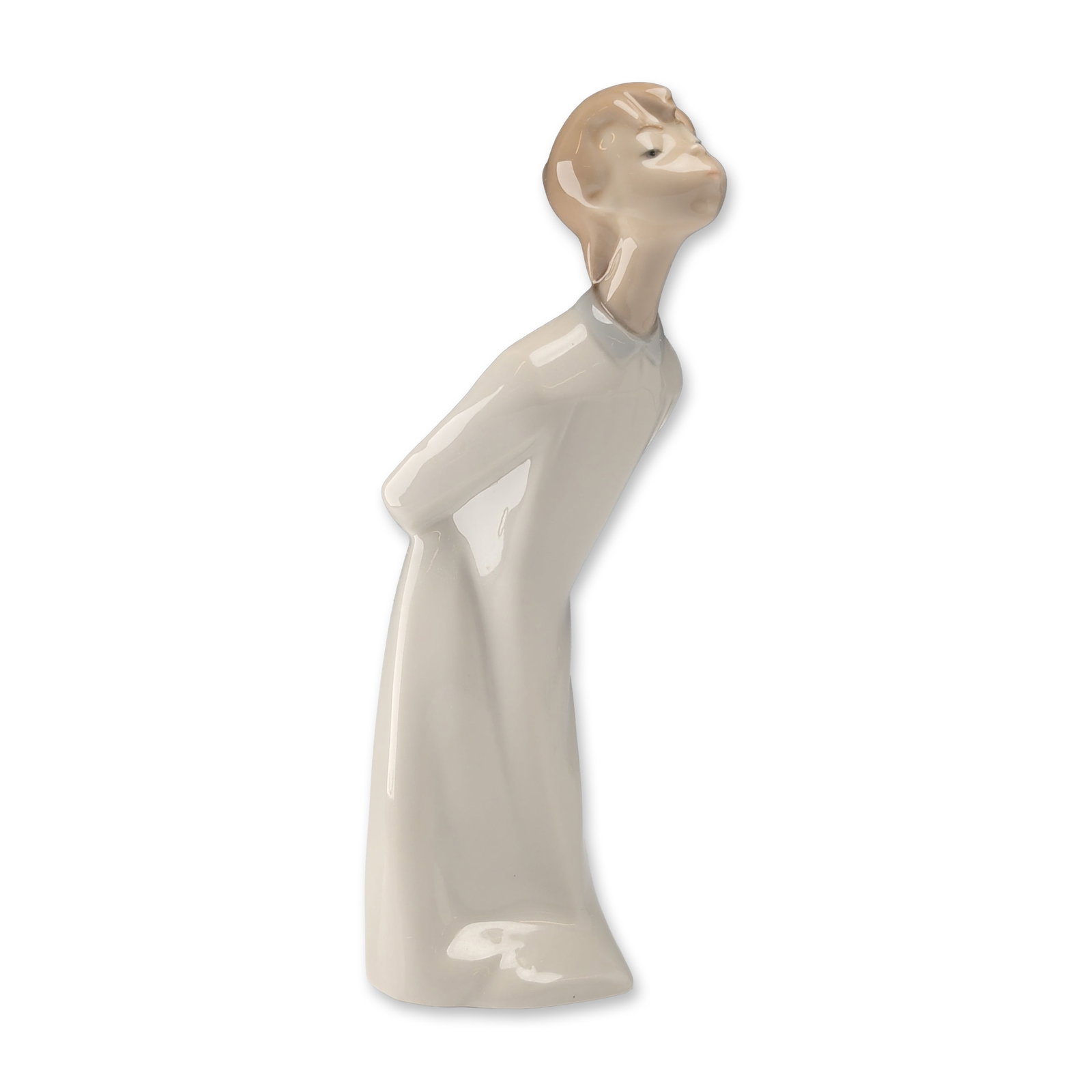 Lladro Spanish Porcelain Boy Kissing Figurine: Lladro, Spain. Glazed porcelain figurine depicting a young boy in a long cream-colored gown, leaning forward with hands tucked behind him. Minimalist design with elongated features and a high-gloss fi