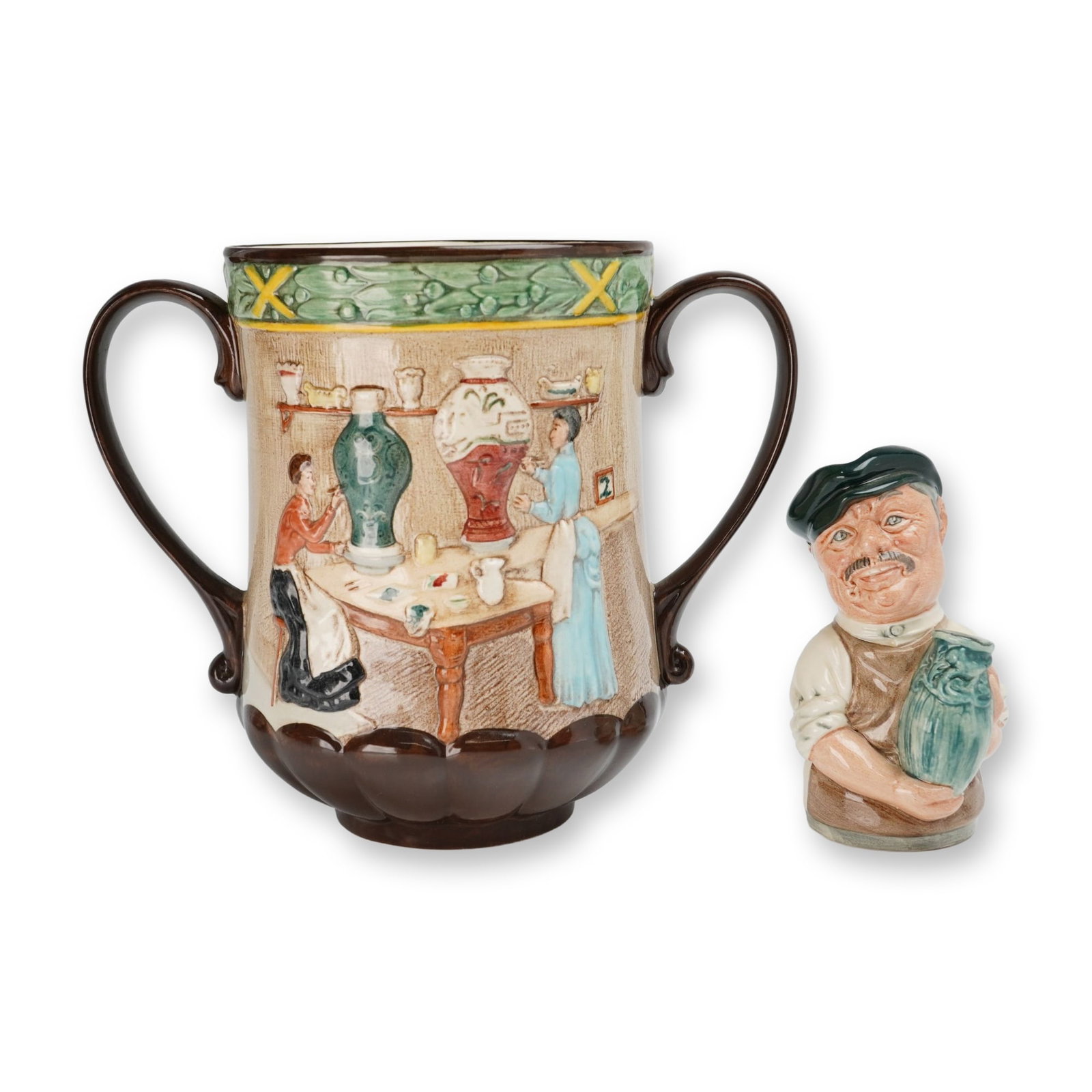 2pc Royal Doulton Pottery In The Past Loving Cup (D6696) and Albert Sagger The Potter (D6745): Royal Doulton glazed earthenware commemorative group of two pieces produced exclusively for the International Royal Doulton Collectors Club. The first item is a Pottery in the Past loving cup,