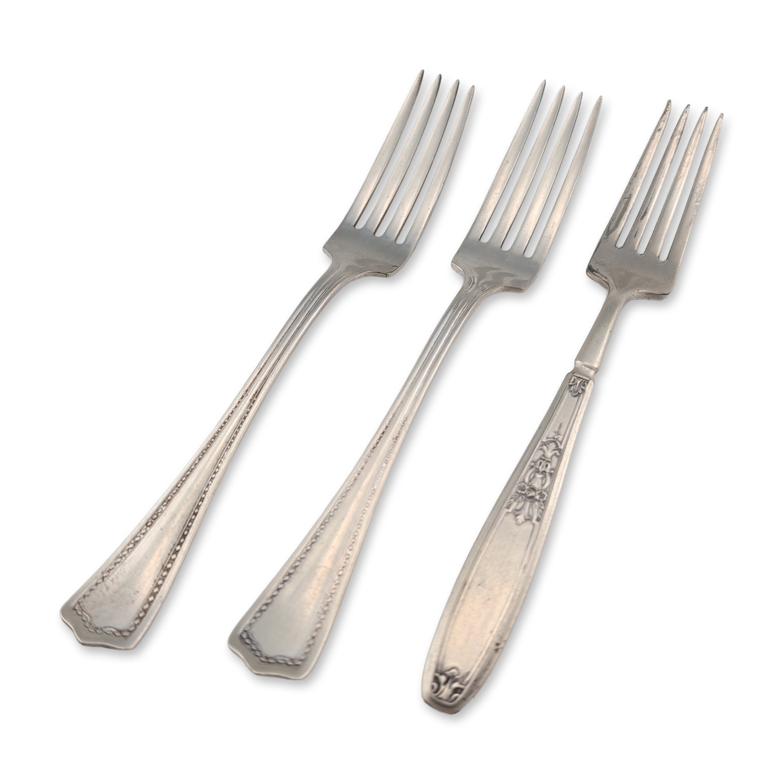 Three 1847 Rogers Bros and William Rogers Silver Plate Forks: The collection includes one fork by 1847 Rogers Bros in the Ambassador pattern, featuring ornate floral and scroll handle motifs, and two forks by William Rogers Mfg. Co. characterized by bracketed sc