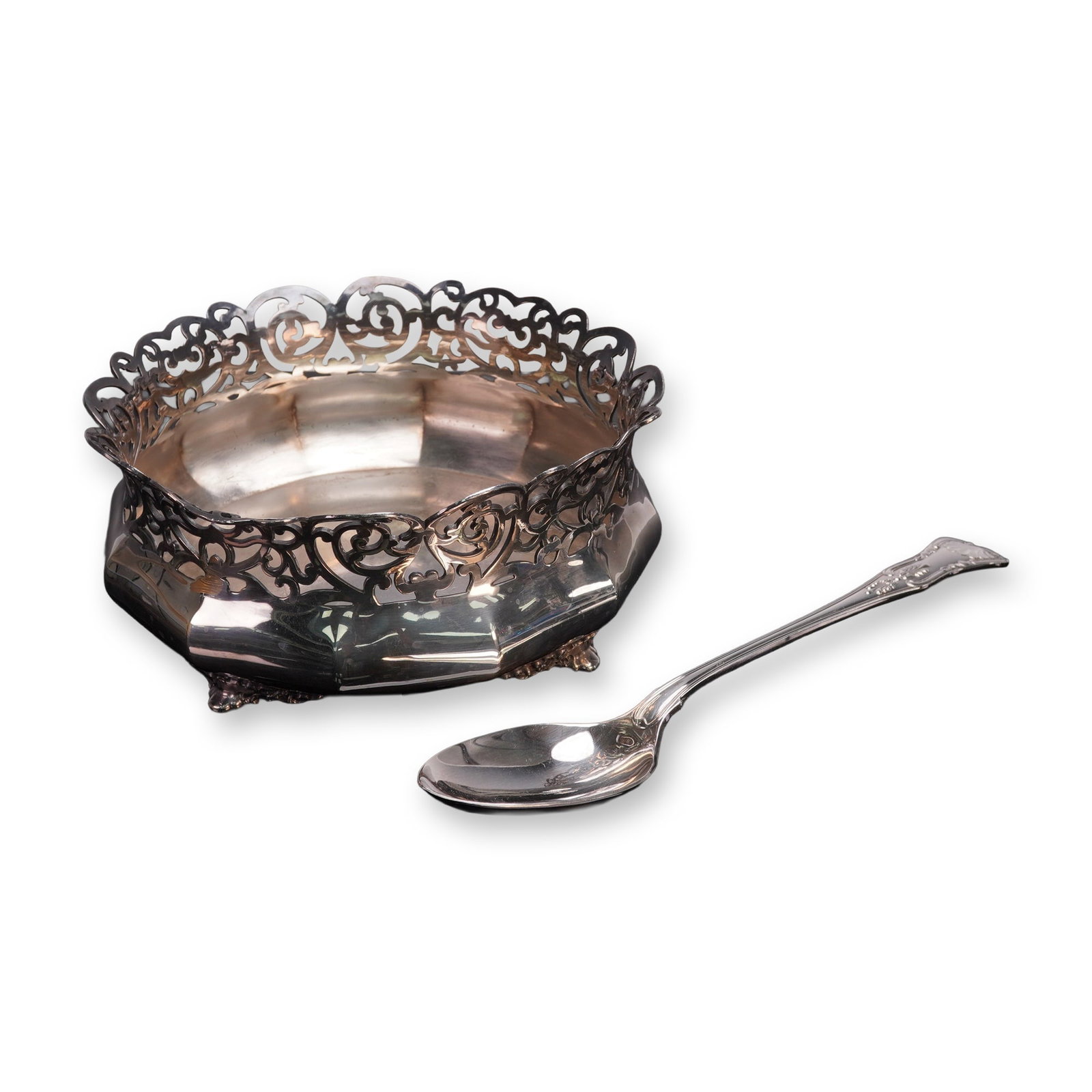 2pc Reed & Barton Silverplate Bowl and Serving Spoon: An elegant set featuring a bowl and serving spoon, the bowl of octagonal form raised on scrolling feet. The spoon's handle adorned with a shell and scroll work and the bowl with pierced border