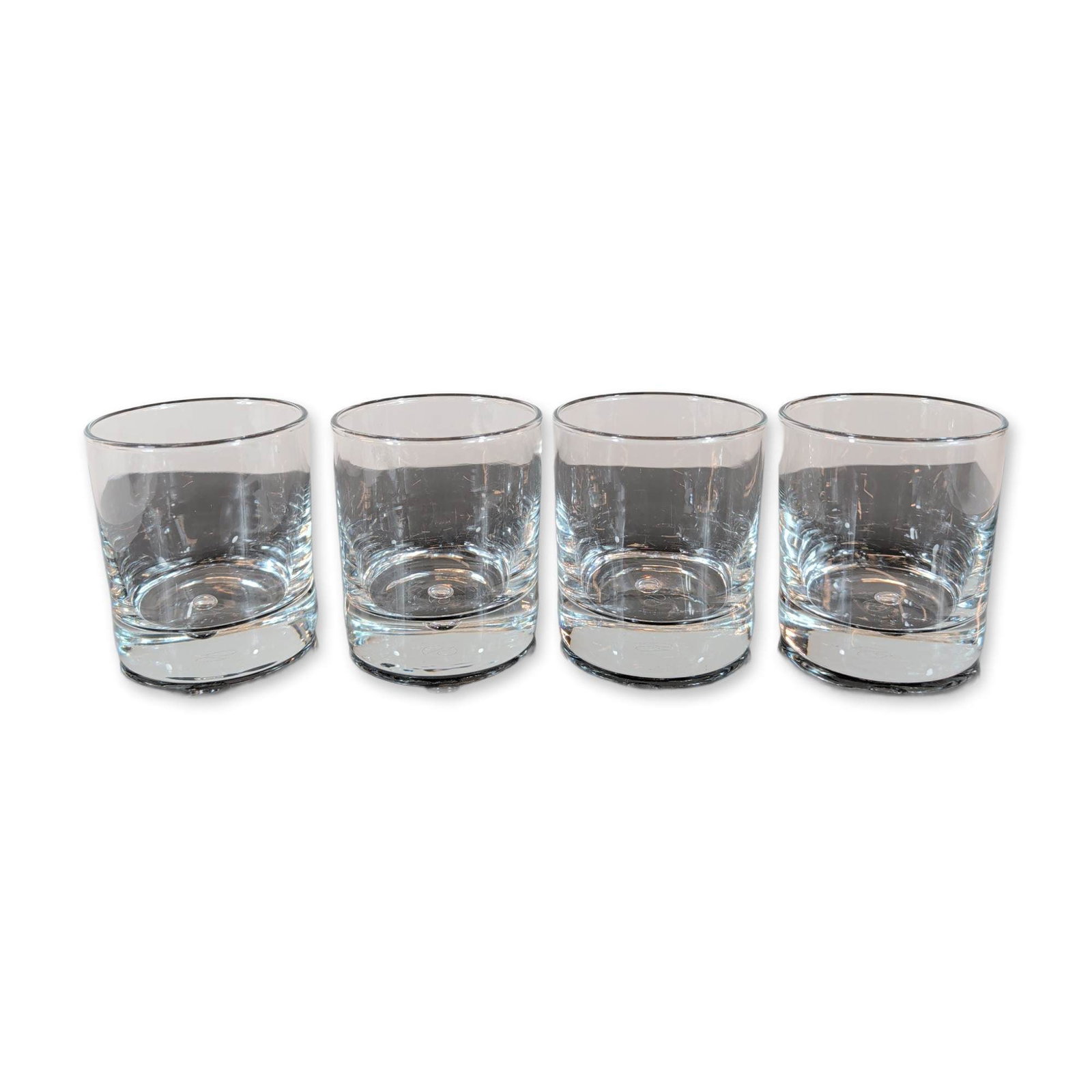 4pc Pasabahce Turkey Crystal Old Fashioned Glasses: Set of four Pasabahce drinking glasses in clear colorless crystal. Each glass features a cylindrical form with a heavy, weighted base detailed with an ergonomic curved indentation. The underside of ea