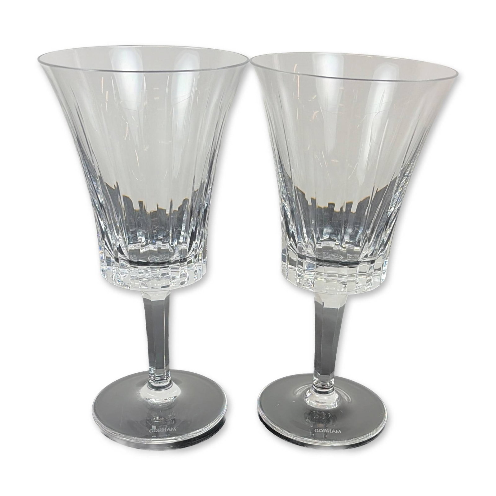 Pair of Gorham Richelieu-Rondo Water Goblets: Each vessel features a trumpet-shaped flared bowl decorated with vertical fluted cuts above a band of deep crisscross diamond accents. The stems are faceted and taper toward a circular foot. The foot 