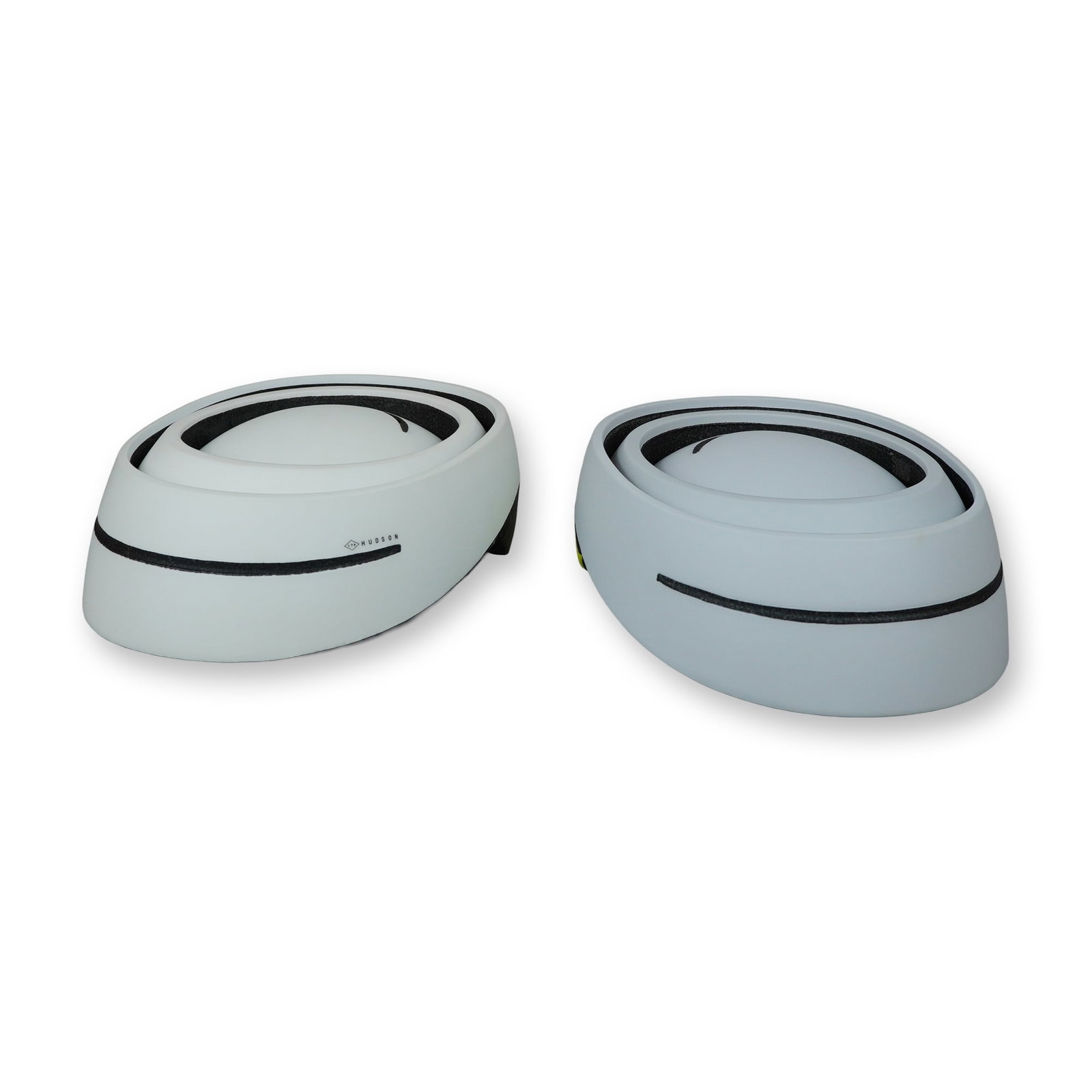 Two Hudson 174 by Closca Collapsible Bicycle Helmets: Two Hudson 174 by Closca collapsible bicycle helmets, featuring a signature telescopic multi-ring folding design for compact storage. One helmet is finished in a white and charcoal grey colorway, and 