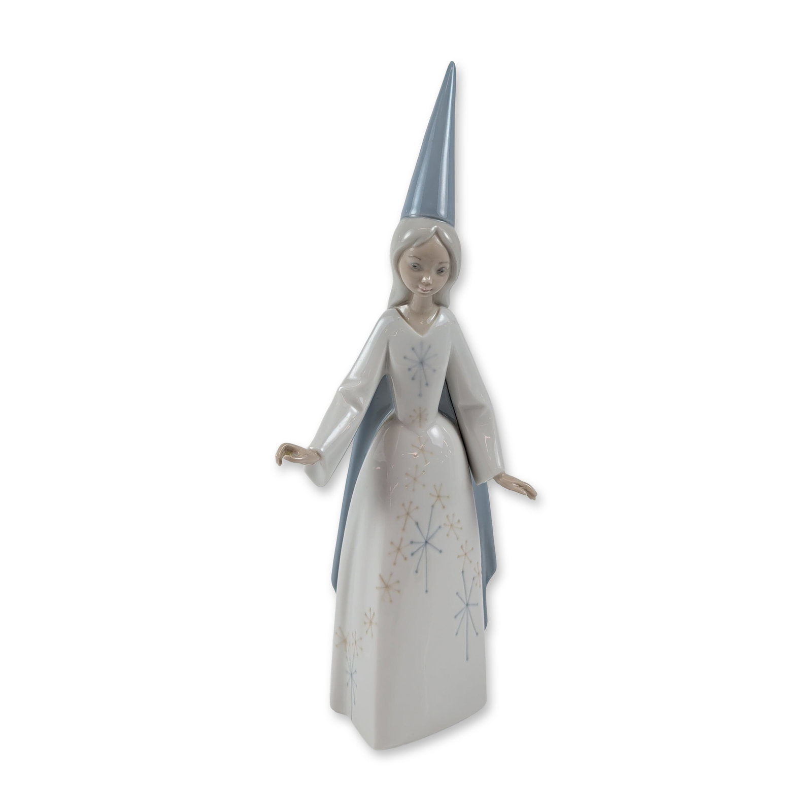 Lladro Spain Porcelain Fairy Figurine: The slender female figure is depicted with arms outstretched, wearing a tall blue pointed hennin-style hat and a white gown decorated with a cascading pattern of blue and gold eight-pointed stars. The