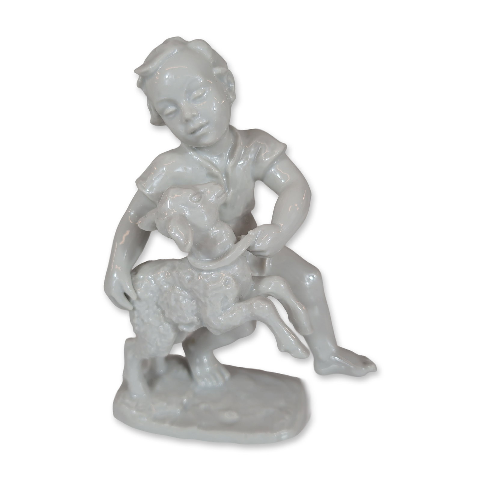 Rosenthal Figurine by Lore Friedrich-Gronau, Boy with Lamb: Rosenthal white glazed porcelain figurine designed by Lore Friedrich-Gronau. The figure depicts a young boy wearing a short-sleeved shirt and shorts kneeling on a textured, naturalistic base while hol