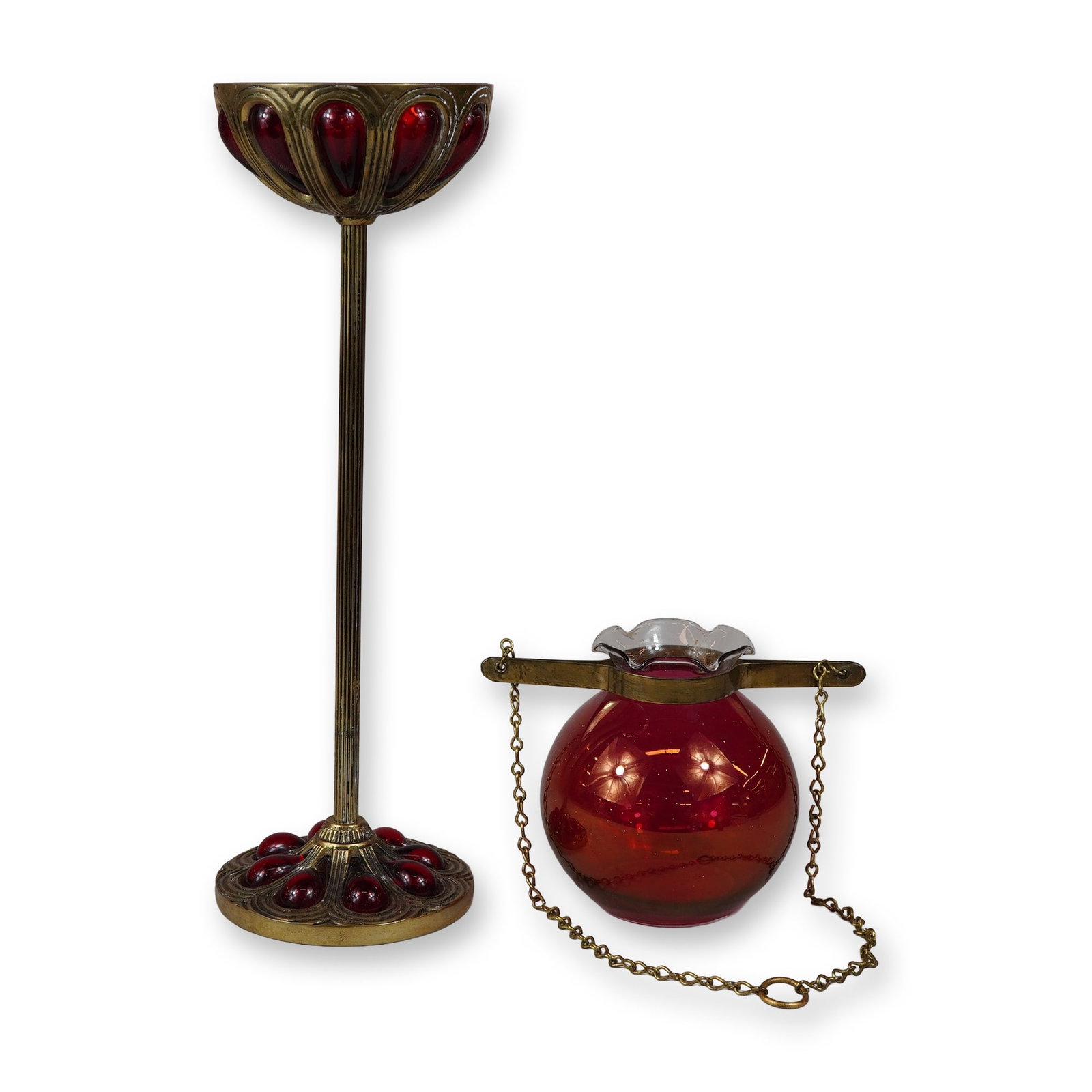 2pc Red Art Glass Brass Candleholders: This lot consists of two ruby red art glass candleholders with brass-toned metal mounts. The first piece is a tall candlestick featuring a shallow circular candle cup supported by a slender, fluted