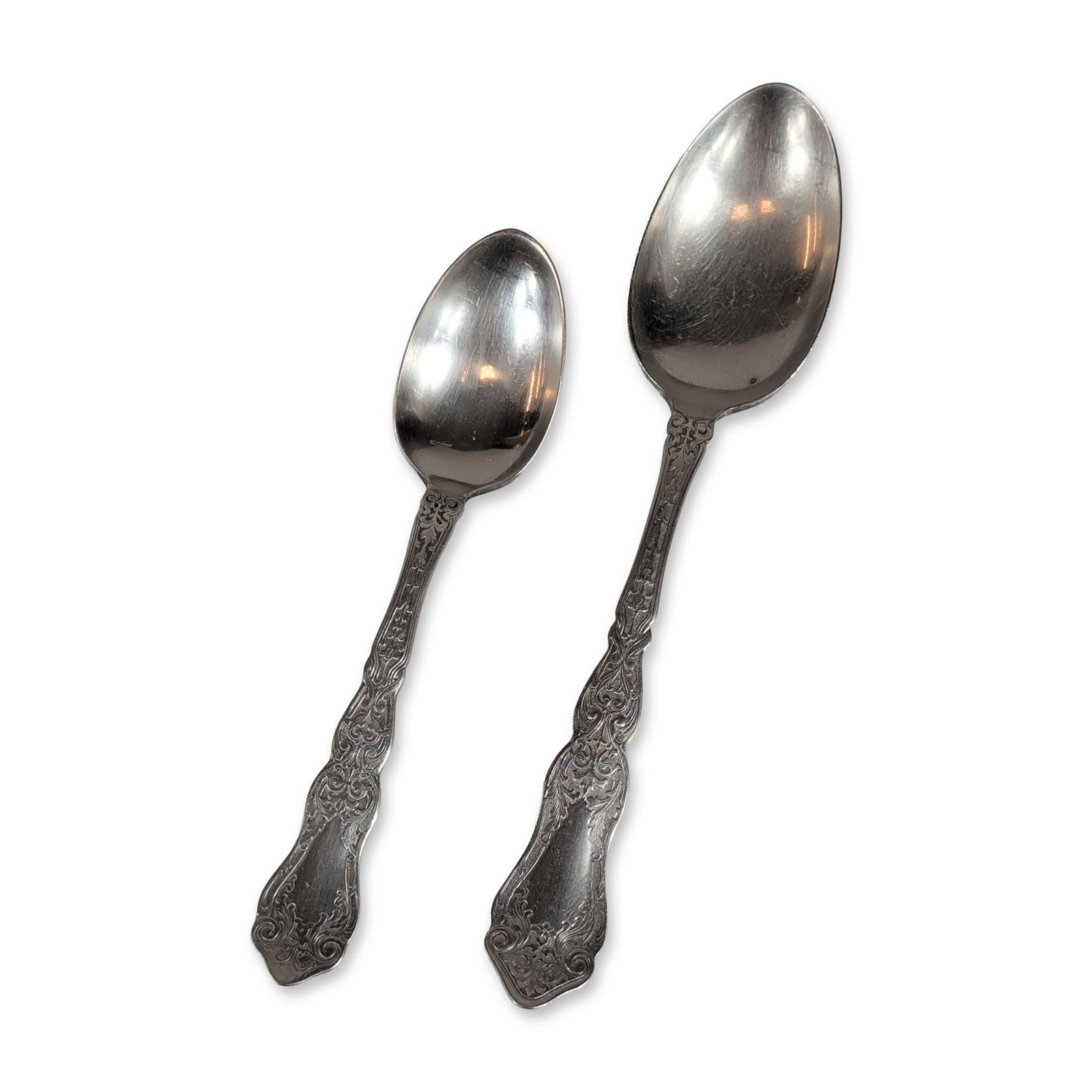 2pc Rogers Sterling Silver Spoons: Comprising one tablespoon and one teaspoon. Each piece features the April pattern handle, characterized by ornate scrolled foliate and floral motifs. The reverse of the handles are stamped ROGERS and
