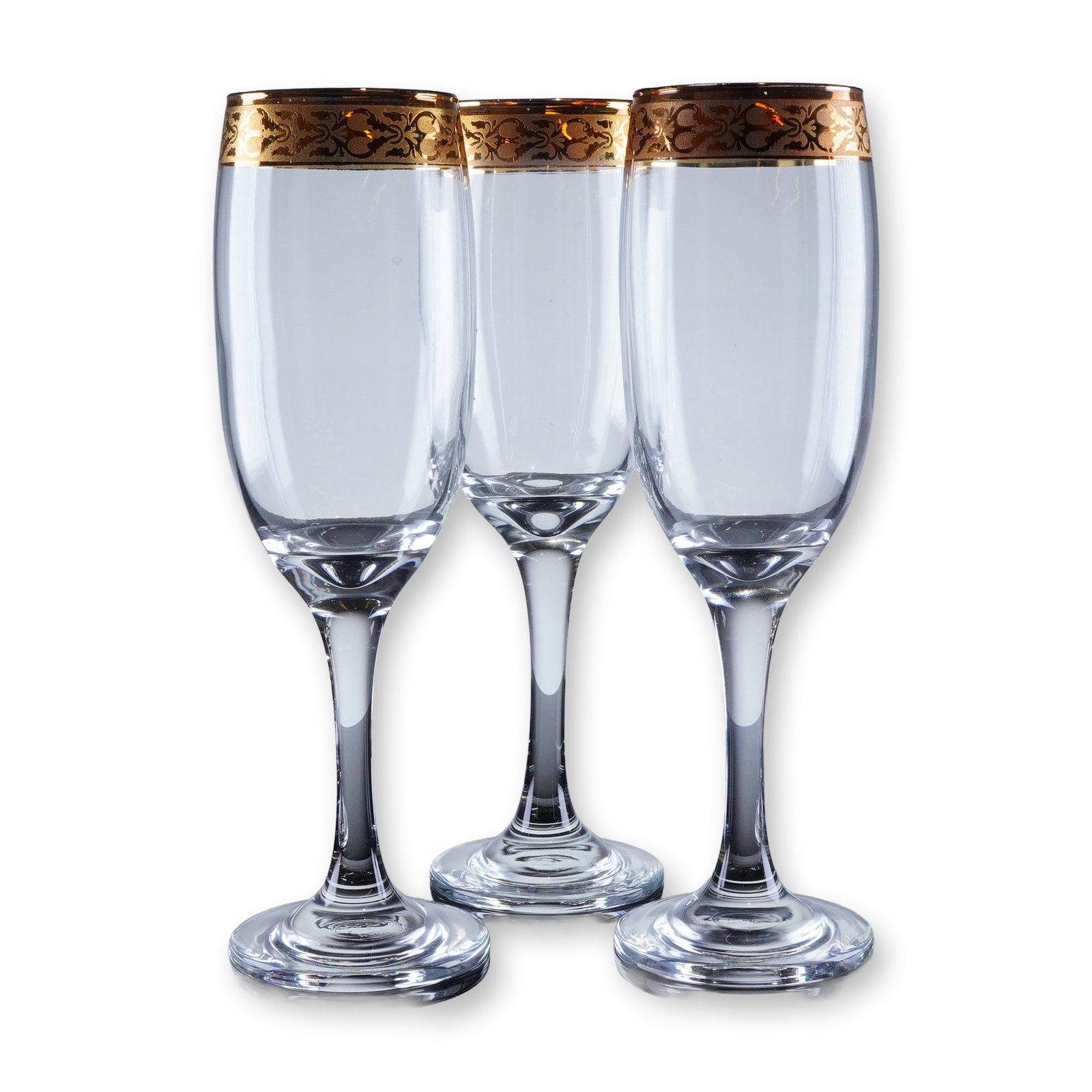 3pc Gold Rim Champagne Flutes: A trio of champagne flutes constructed of clear glass and featuring a tall, narrow bowl, slender stem, and circular foot. The defining characteristic is the wide, continuous band of intricate gold dec