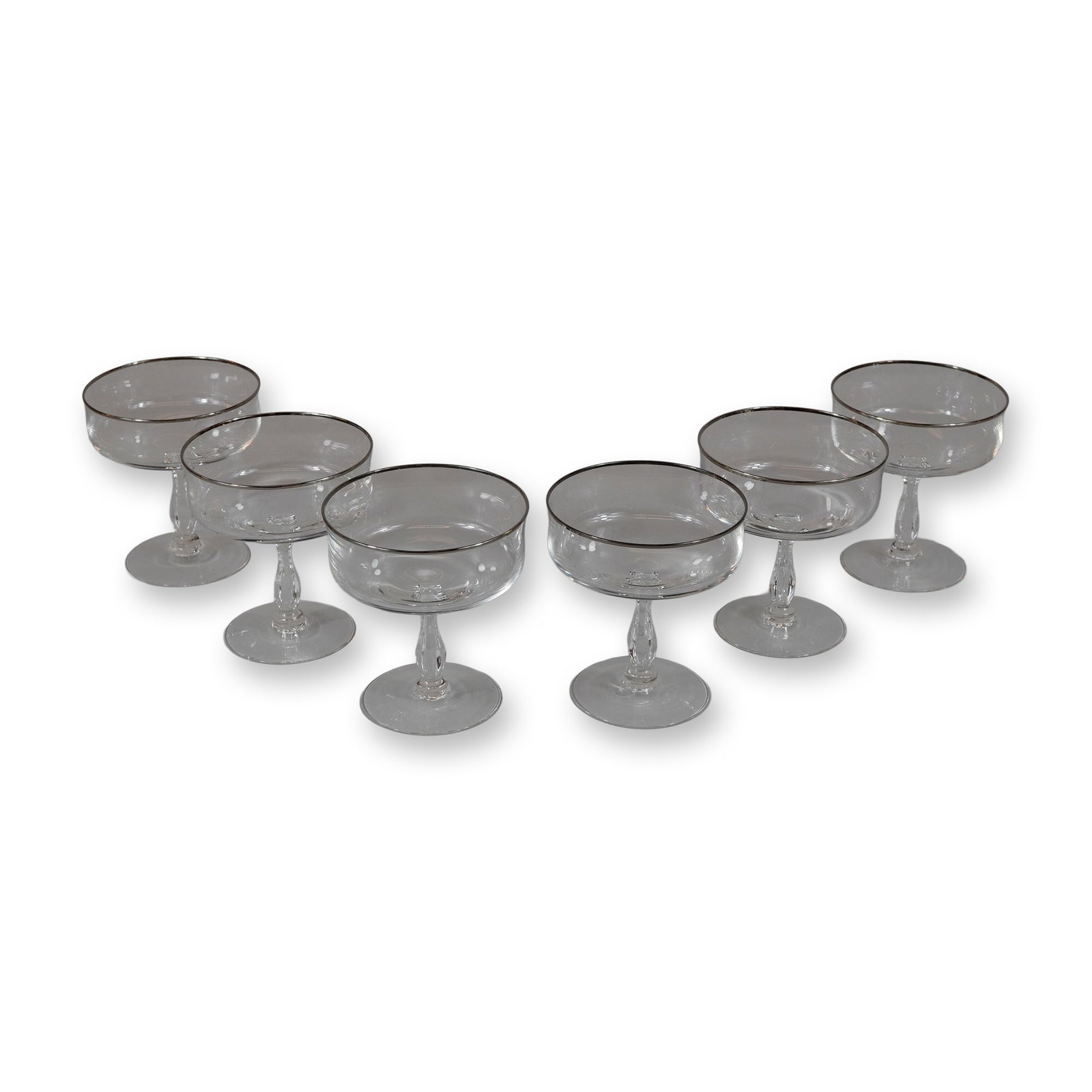 6pc Glass Champagne Coupe Glasses with Silver Toned Rims: A set of six vintage clear glass coupe-style vessels, suitable for use as champagne, cocktail, or tall sherbet glasses. Each glass features a hand-painted metallic silver toned luster band around the