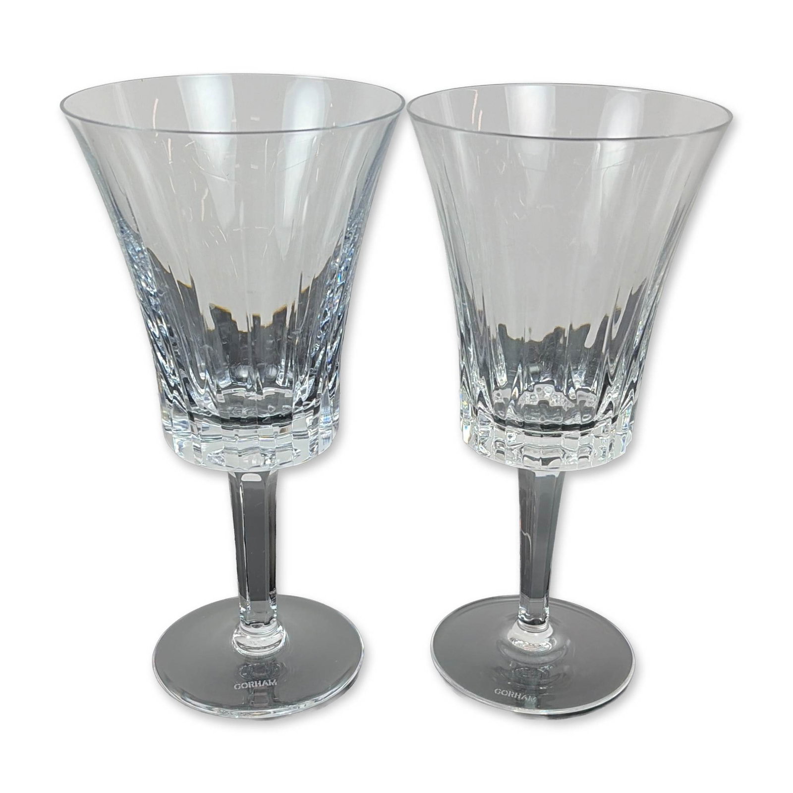Pair of Gorham Richelieu-Rondo Water Goblets: Each vessel features a trumpet-shaped flared bowl decorated with vertical fluted cuts above a band of deep criss-cross diamond accents. The stems are faceted and taper toward a circular foot. The foot