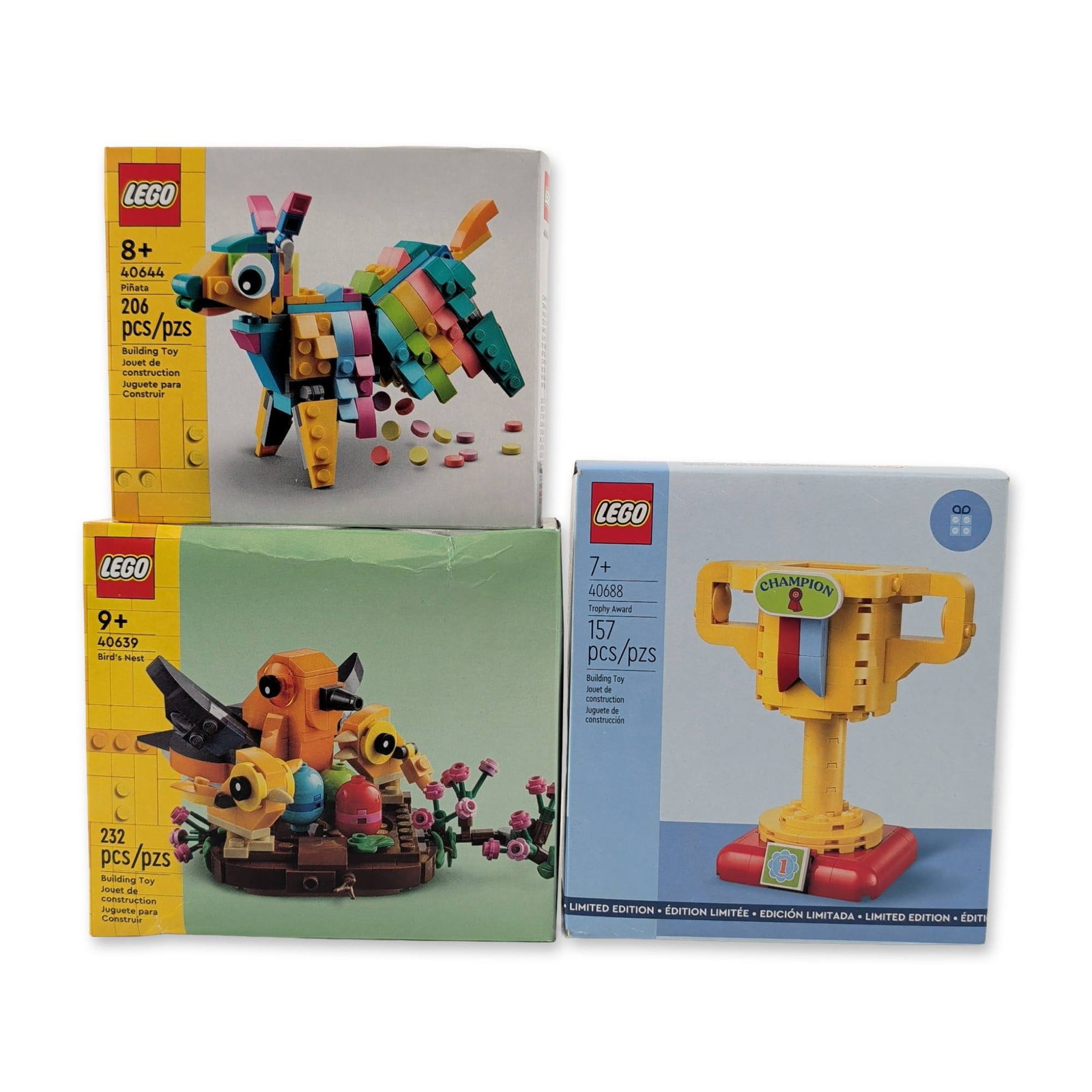 Three LEGO Factory Sealed Building Sets: LEGO. Group of three building sets in molded plastic, comprising Set 40644 Pinata, Set 40639 Bird's Nest, and Set 40688 Trophy Award. Set 40644 features a hinged donkey with internal brick elements.