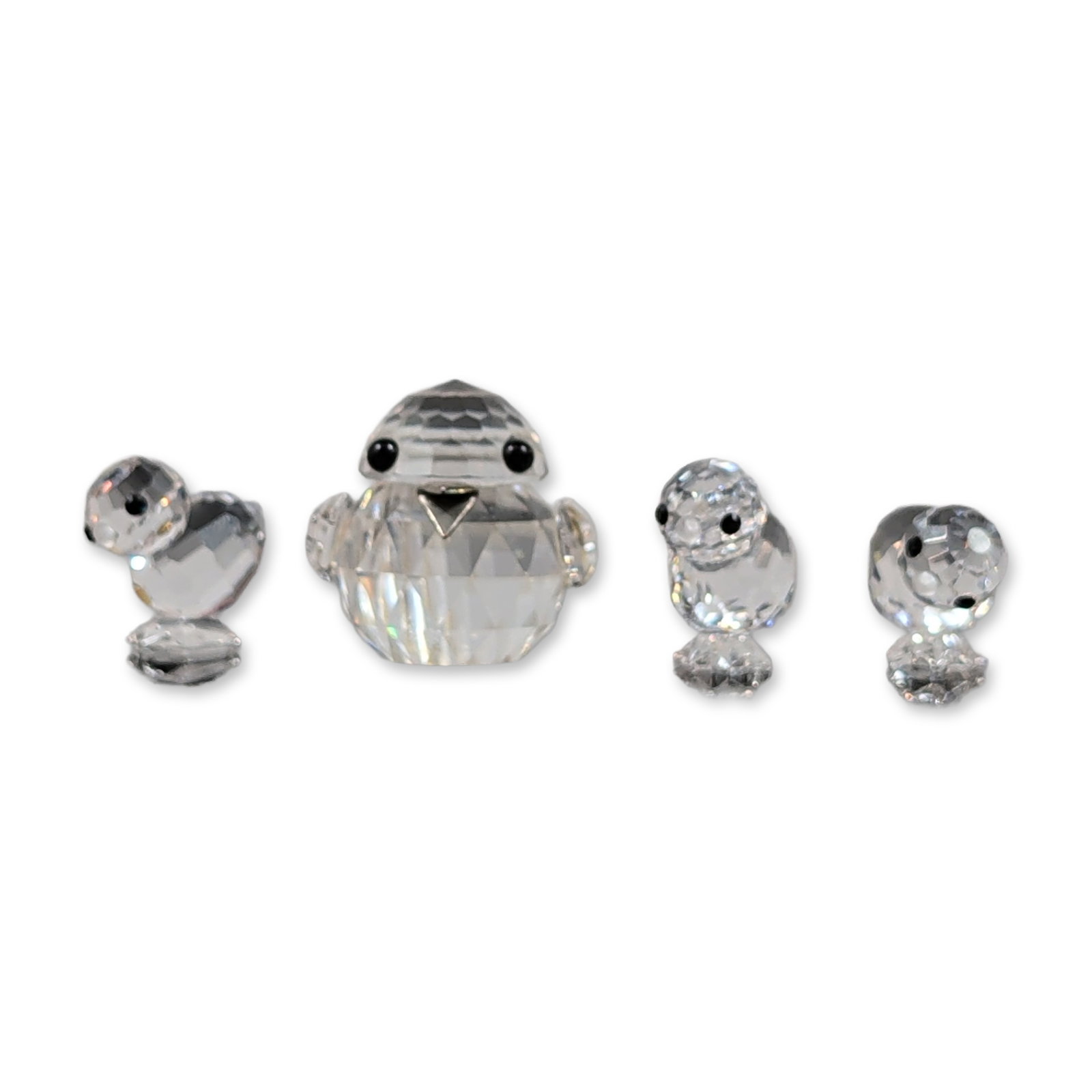 Set of Four Swarovski Faceted Crystal Bird Figurines: Swarovski set of four bird figurines crafted in faceted lead crystal, featuring a sparrow and three chicks. Each piece is designed with multifaceted spherical shapes and inset black eyes. All bear