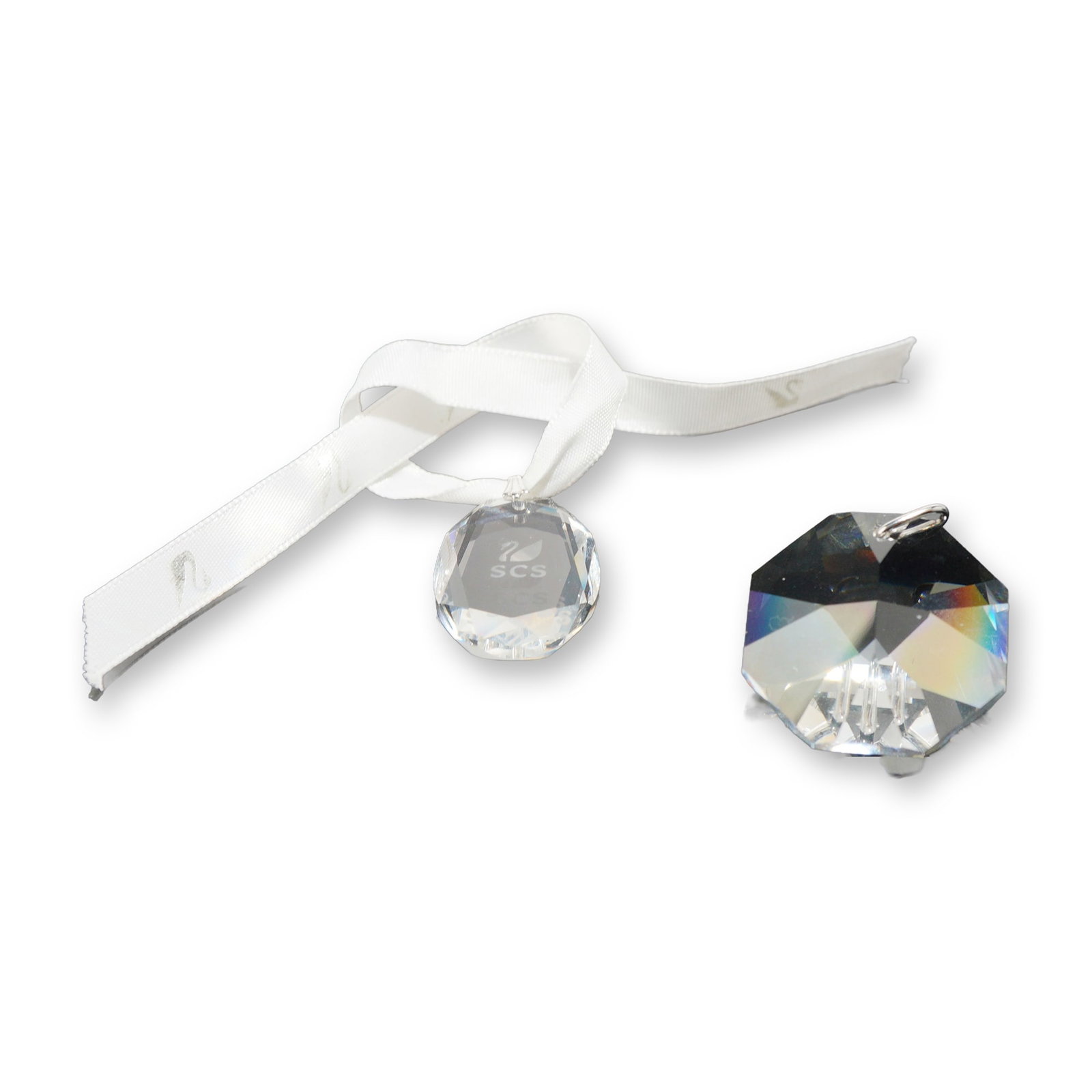 Two Swarovski SCS Faceted Lead Crystal Ornaments: Two faceted lead crystal pieces including an oval Swarovski Crystal Society (SCS) medallion and a large octagonal prism. The SCS medallion features an etched swan logo backstamp and is attached to a b