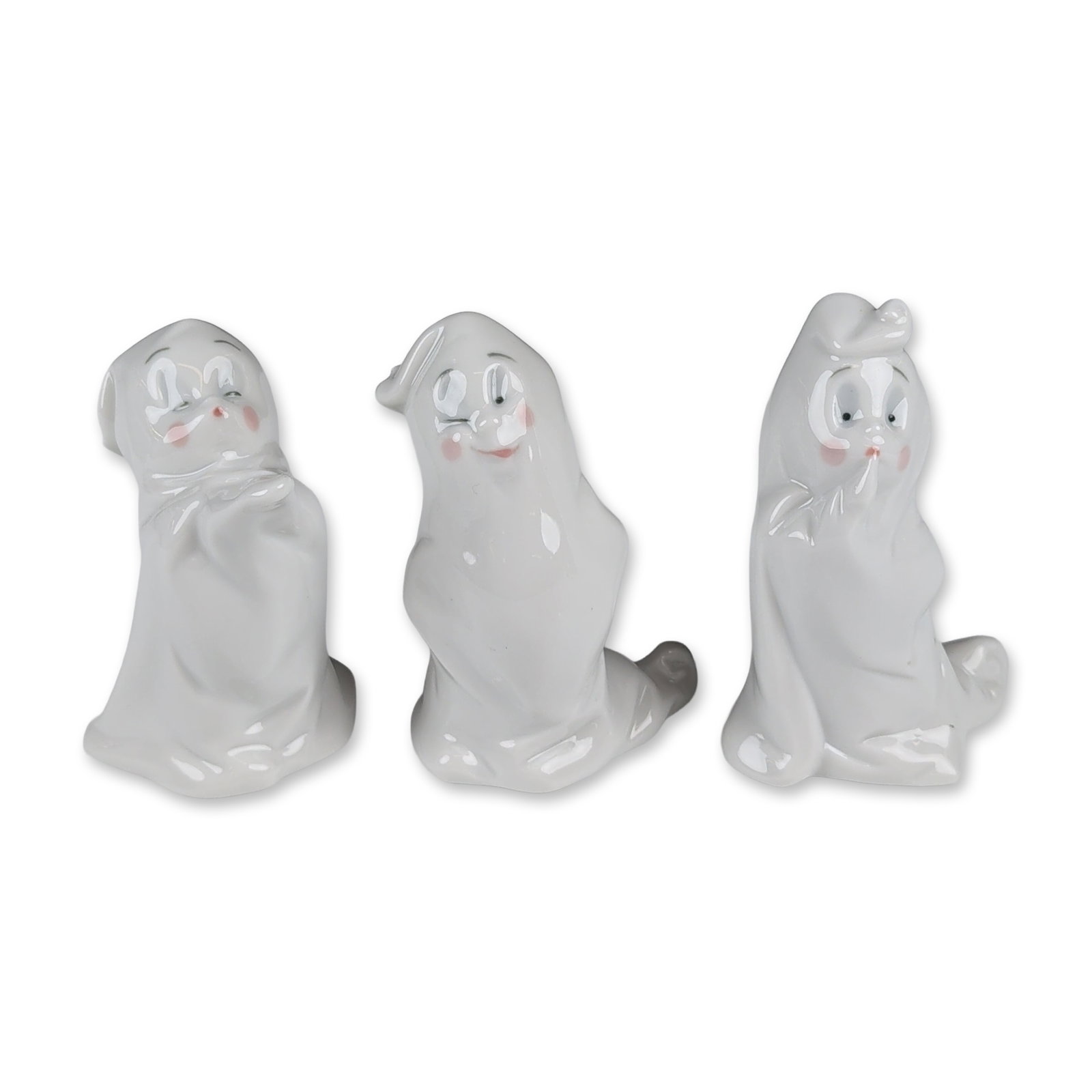 3pc NAO Spain Jeepers Creepers Ghost Figurines: A set of three glazed porcelain ghost figurines from the Jeepers Creepers collection which features stylized forms in various playful poses, brought to life with hand-painted blue eyes, blushing cheek