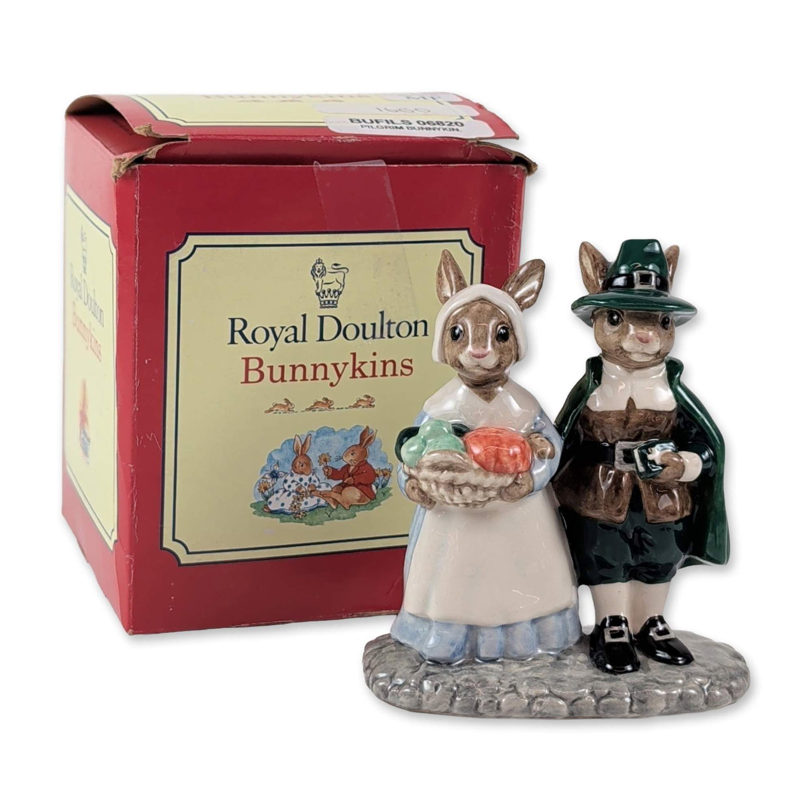 Royal Doulton Pilgrim Bunnykins Ceramic Figurine: Royal Doulton. Pilgrim Bunnykins ceramic figurine, model DB 212, depicting two anthropomorphic rabbits in traditional pilgrim attire. The male figure is dressed in a green buckled hat, cloak, and brow