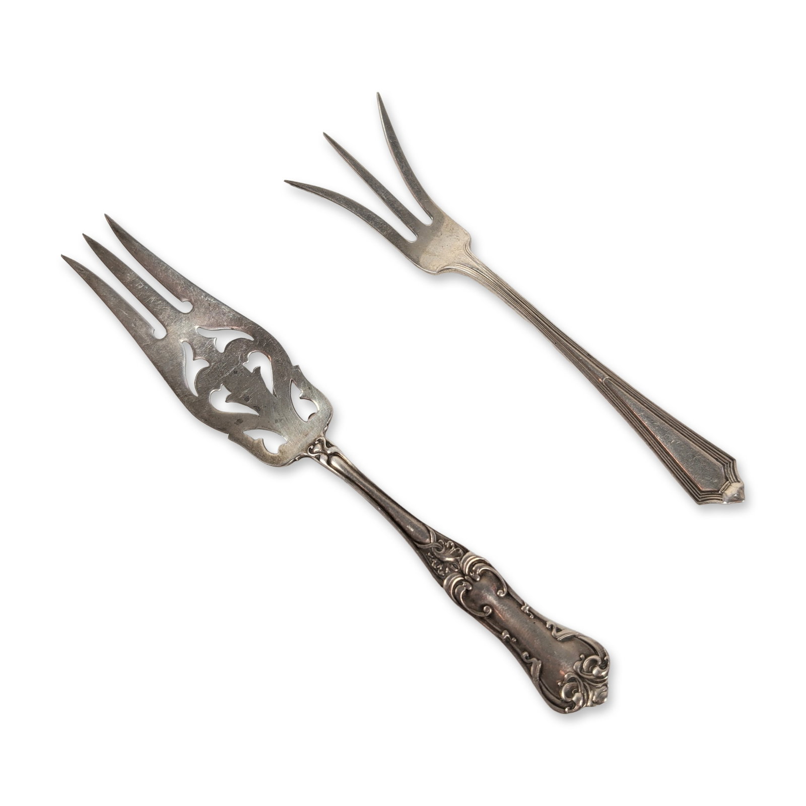 2pc Sterling Silver Serving Forks includes Gorham: This collection includes two sterling silver serving forks. The first is a relish fork with a floral-embossed handle and a pierced decorative bowl with three tines, marked Sterling and Pat. 03 with a 