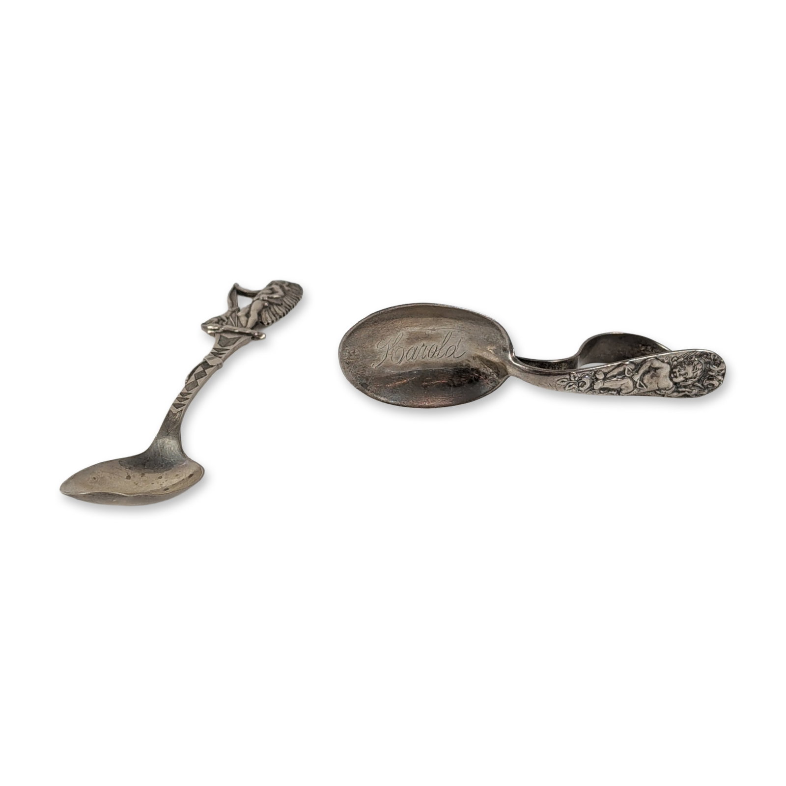 2pc Sterling Silver Spoons, Indian Chief & Cherub Spoon includes Lunt: The baby spoon features a curved handle decorated with a relief-molded putto and foliate scrollwork, with the bowl hand-engraved with the name Harold. It bears the mark PAT OCT 31, 1899. The souvenir