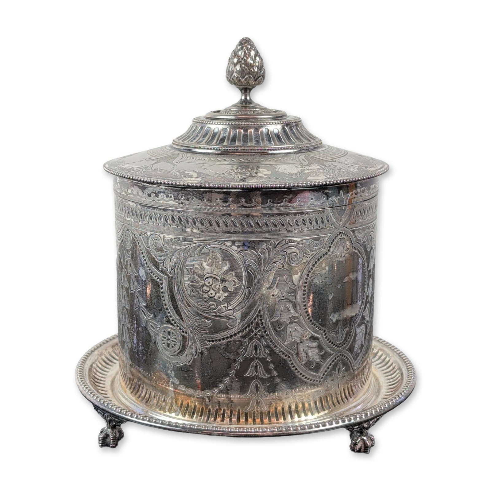 George V EPNS Silver Plated Engraved Biscuit Barrel, Atkin Brothers: This silver-plated biscuit barrel, likely by the Atkin Brothers of Sheffield, sits on an integrated stand. The cylindrical body and hinged lid are richly decorated with bright-cut engravings of foliat