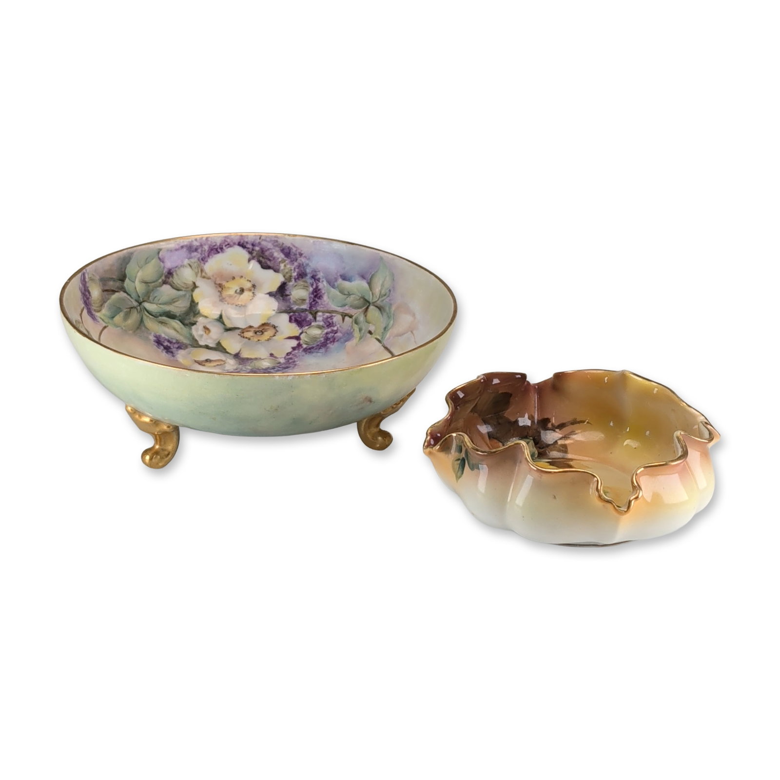 2pc Tressemanes & Vogt Limoges French and Morimura Bros Nippon Japanese Floral Bowls: The Tressemann and Vogt Limoges footed bowl features an interior spray of white blossoms and purple flowers, a mottled green and blue exterior, and three scrolling gilded feet. The Nippon bowl by