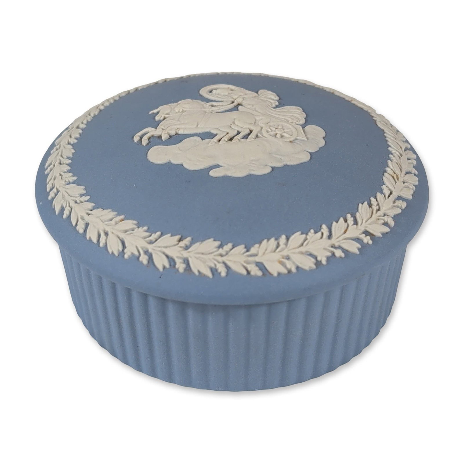 Wedgwood Blue Jasperware Treasure Box: Wedgwood. Round lidded trinket box in pale blue jasperware, featuring white bas-relief classical decoration. The lid depicts a horse and chariot scene within a laurel wreath border. The exterior body 