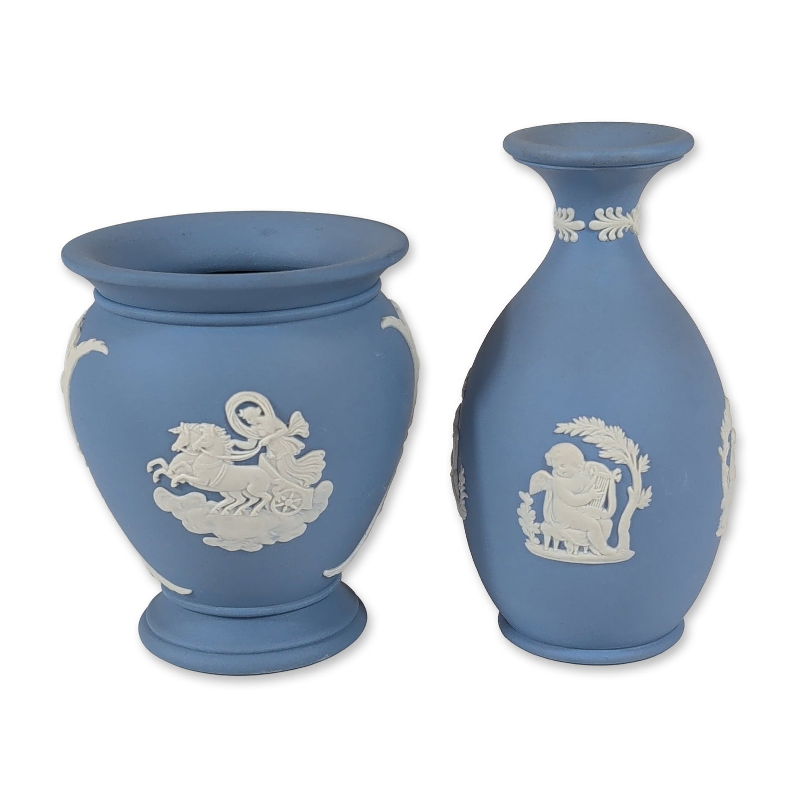 2pc Wedgwood Blue Jasperware Vases: Wedgwood, England. Two vases in light blue jasperware featuring white bas-relief Neoclassical scenes including figures in a chariot, a figure with a lyre under a tree, and standing classical female fi
