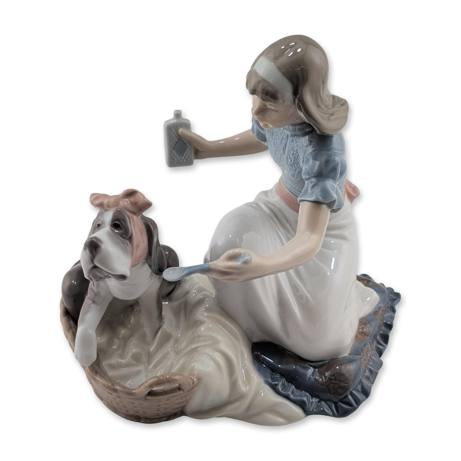 Lladro Take Your Medicine Figurine: Lladro (Spain) glazed porcelain figurine, model number 5921, titled Take Your Medicine. The piece depicts a young girl kneeling in a blue blouse and white skirt with a pink bow, administering medicine