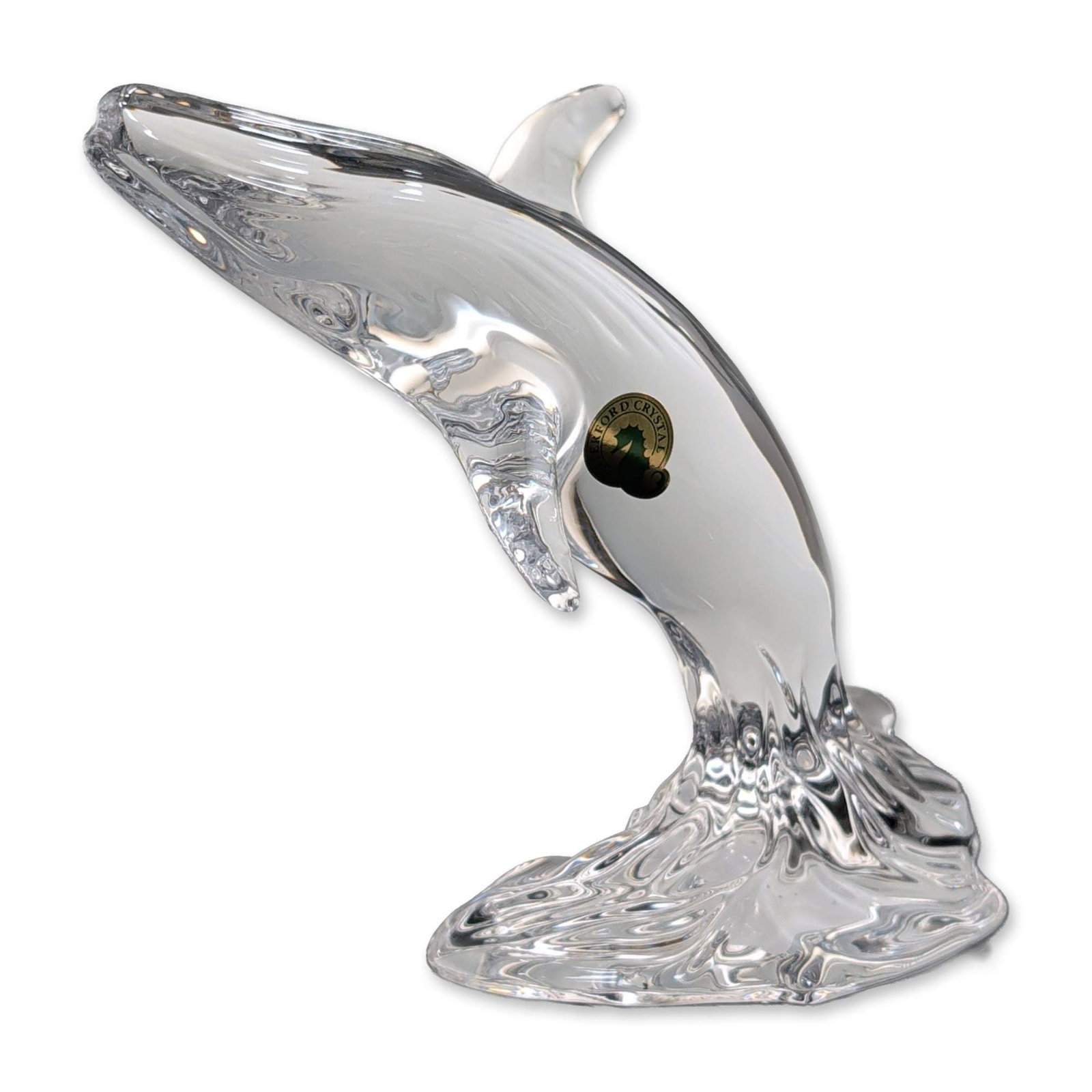 Waterford Lead Crystal Whale Figurine: Waterford Crystal. Figurine in clear lead crystal, depicting a breaching whale rising from a stylized splashing water base. Features a polished form with defined dorsal fin and flukes. Signed with etc