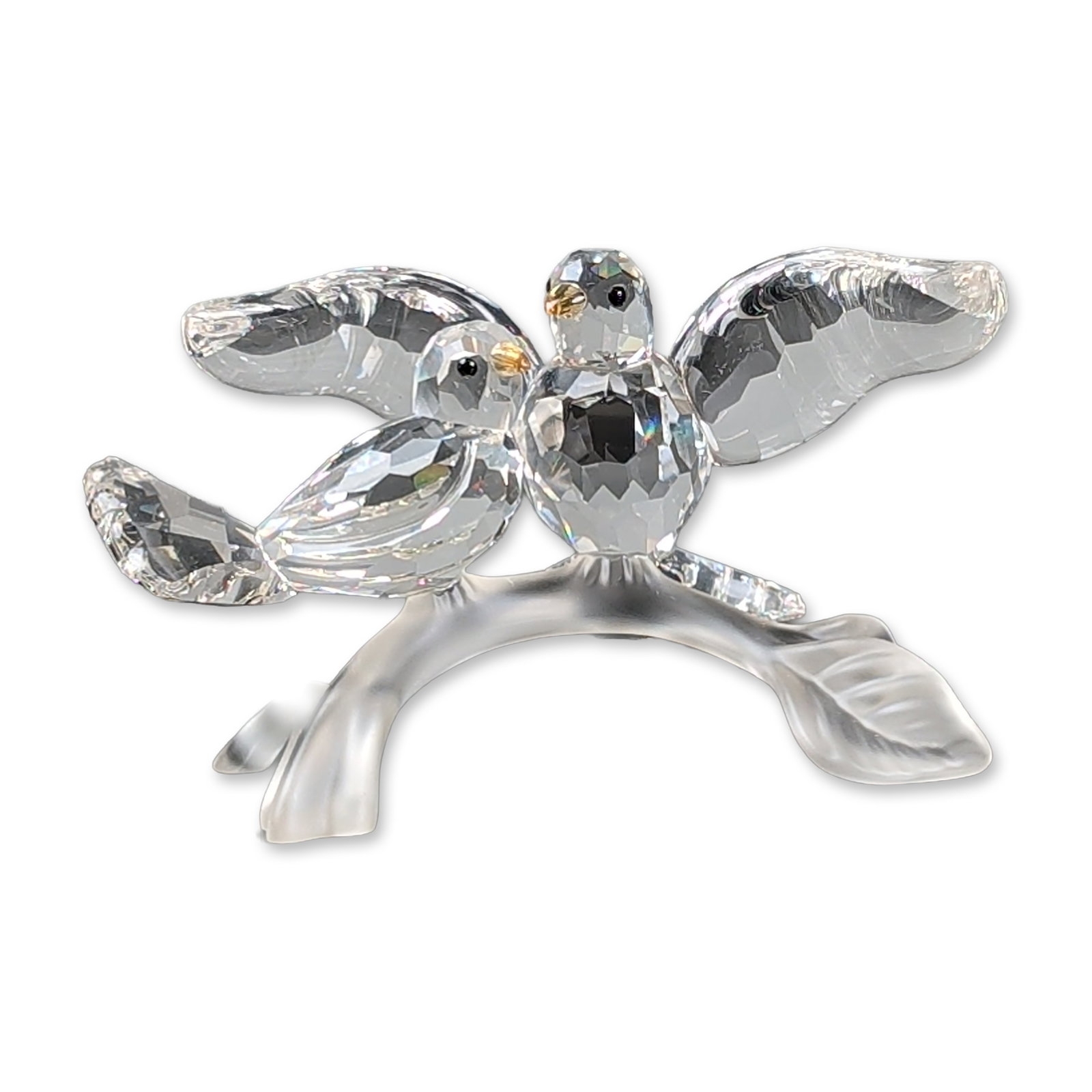 Swarovski Crystal Figurine, Turtledoves: Figurine in faceted clear and frosted crystal, depicting two turtledoves perched on a branch. The birds are rendered in multi-faceted clear crystal with inset dark eyes. The supporting branch and two 