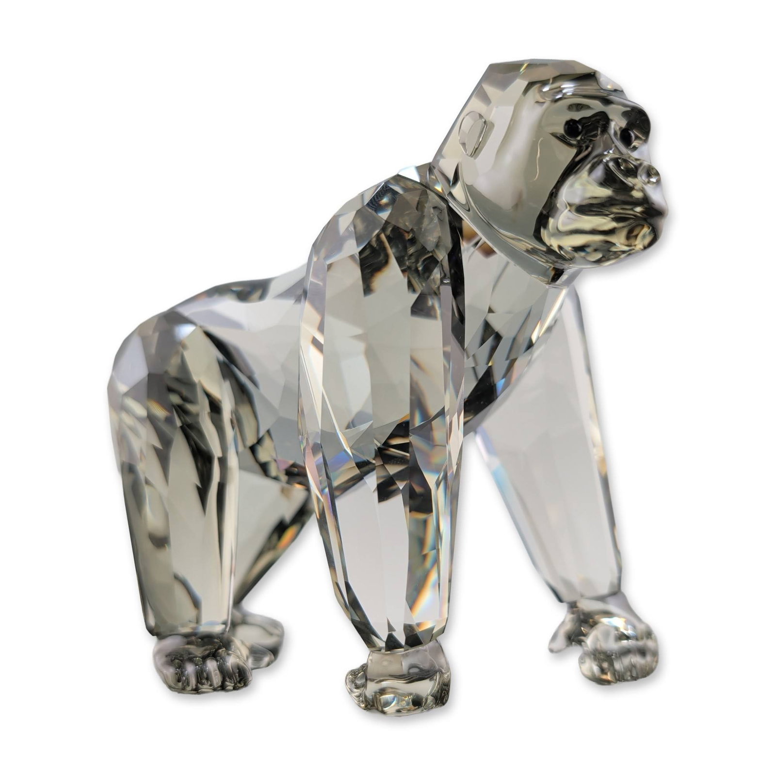 Swarovski Crystal Gorilla Mother Figurine: Swarovski. Gorilla figurine in faceted lead crystal, featuring a walking posture with precision-cut facets to refract light. The underside of the hind paw is etched with the Swarovski swan logo, the S