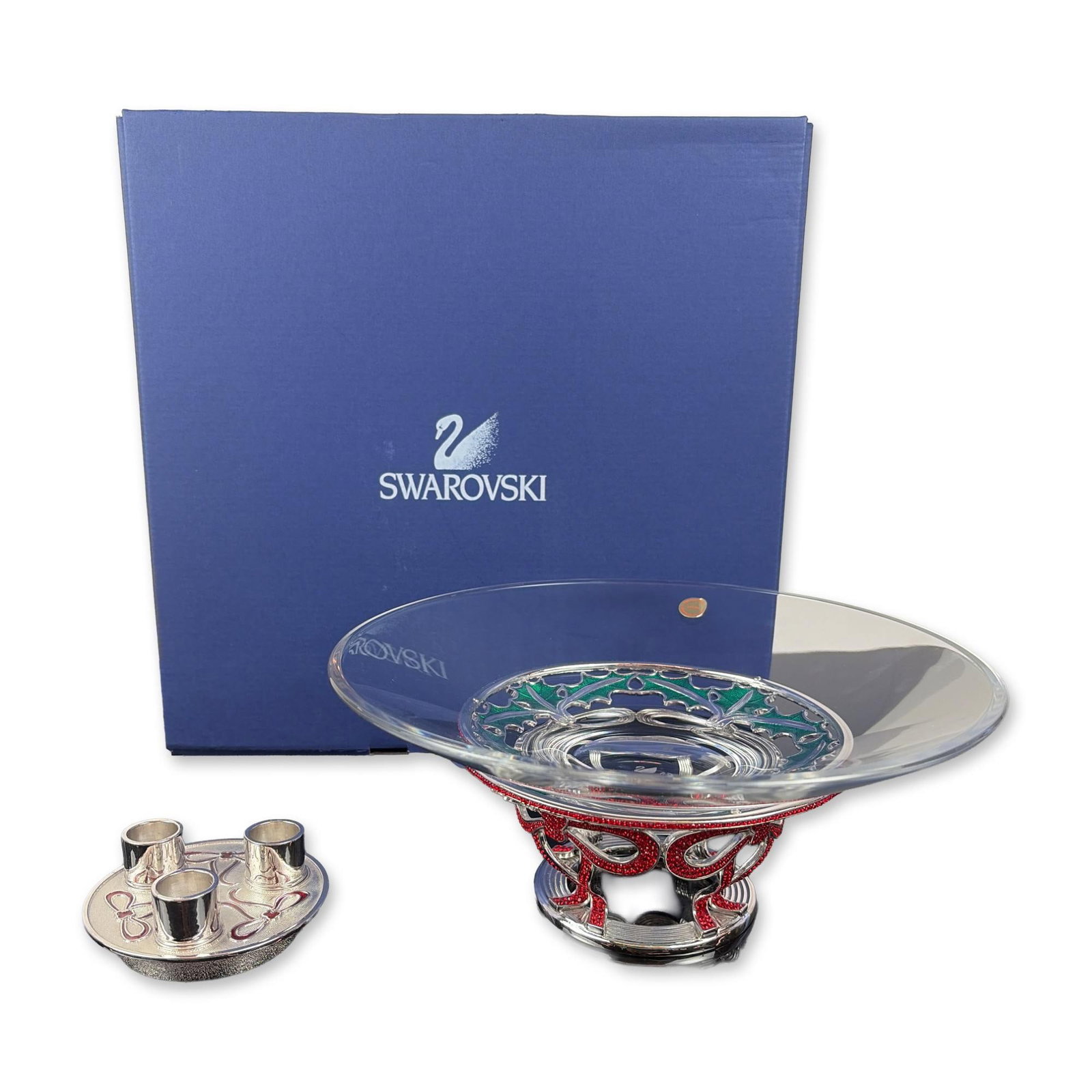 Swarovski Crystal Holiday Centerpiece Bowl and Candleholder Set: Swarovski. Holiday centerpiece set in clear crystal glass and silver-tone metal, comprising a flared glass bowl, a decorative holly leaf base ring with green enamel and faceted red crystal accents, an
