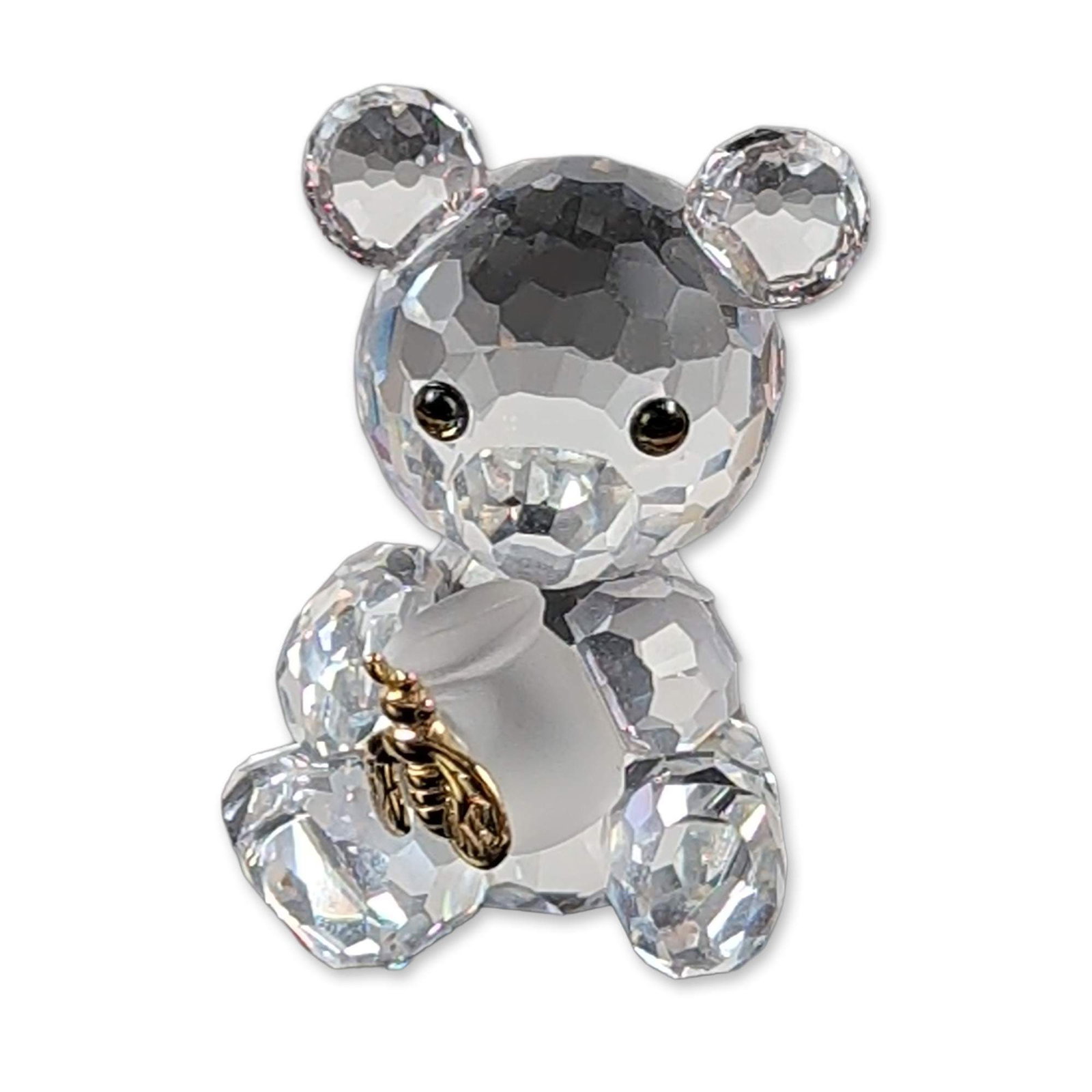 Swarovski Crystal Kris Bear with Bee Figurine: Swarovski faceted lead crystal figurine from the Kris Bear series. The figure depicts a teddy bear with polychrome eyes holding a frosted crystal pot featuring a gold-toned metal bee. Includes the etc
