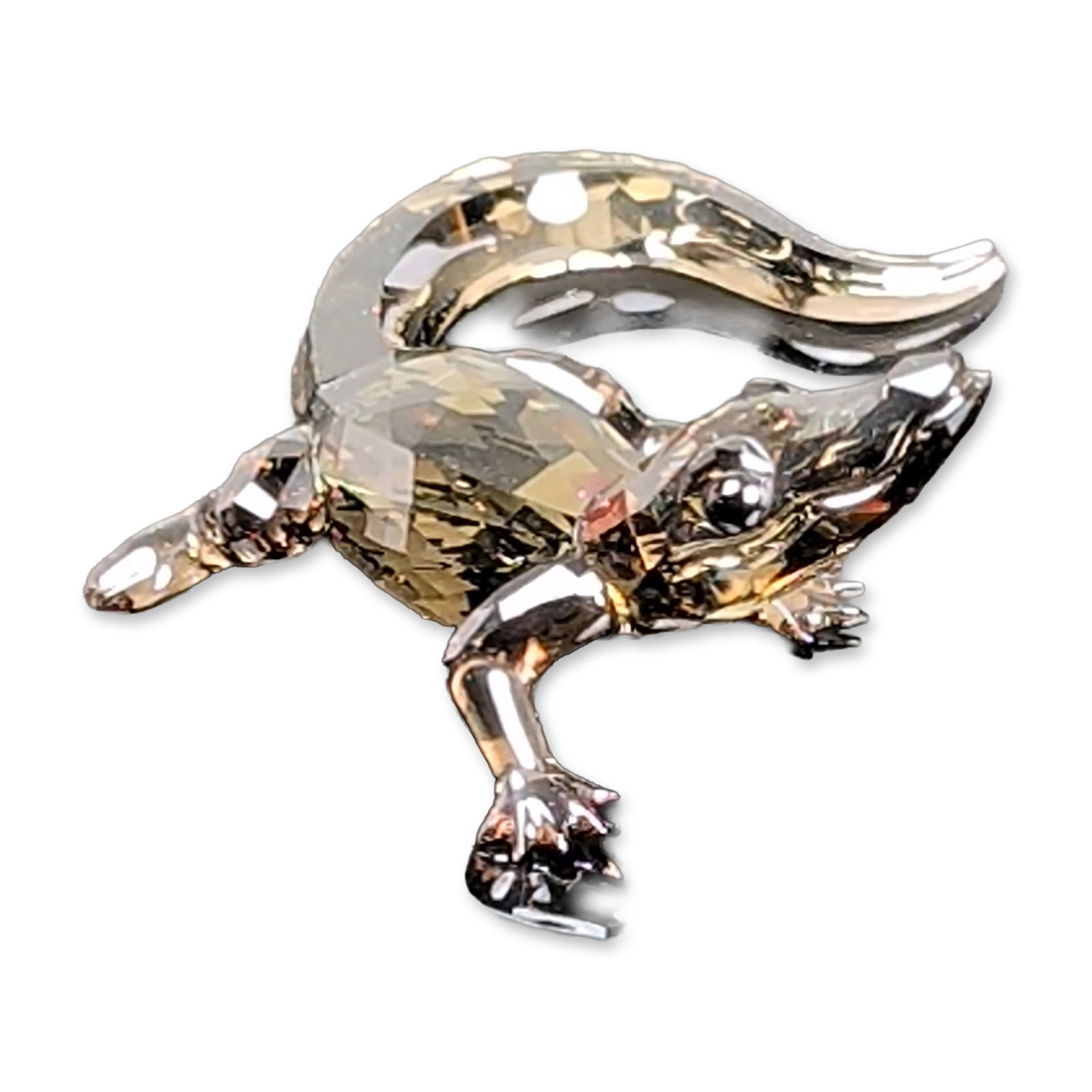 Swarovski Faceted Crystal 2016 Event Figurine, Baby Crocodile: Baby crocodile figurine in faceted Jet and Golden Shadow crystal, featuring a stylized climbing pose with four polished silver-tone metal limbs and black bead eyes. Etched with factory swan logo on th