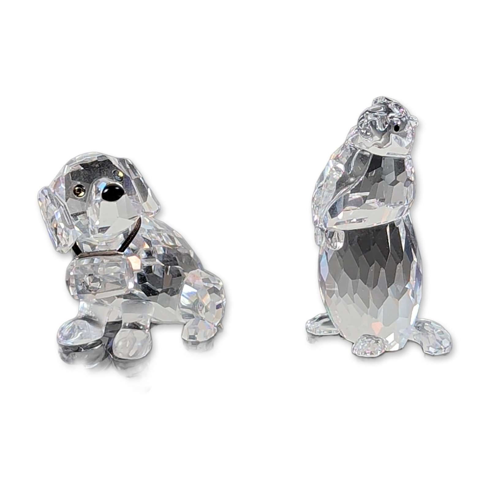 Pair of Swarovski Crystal Animal Figurines: A charming Swarovski set featuring two faceted lead crystal animal figurines: a seated St. Bernard with colorful eyes and a tiny barrel around its neck, and a watchful groundhog with shiny black beade