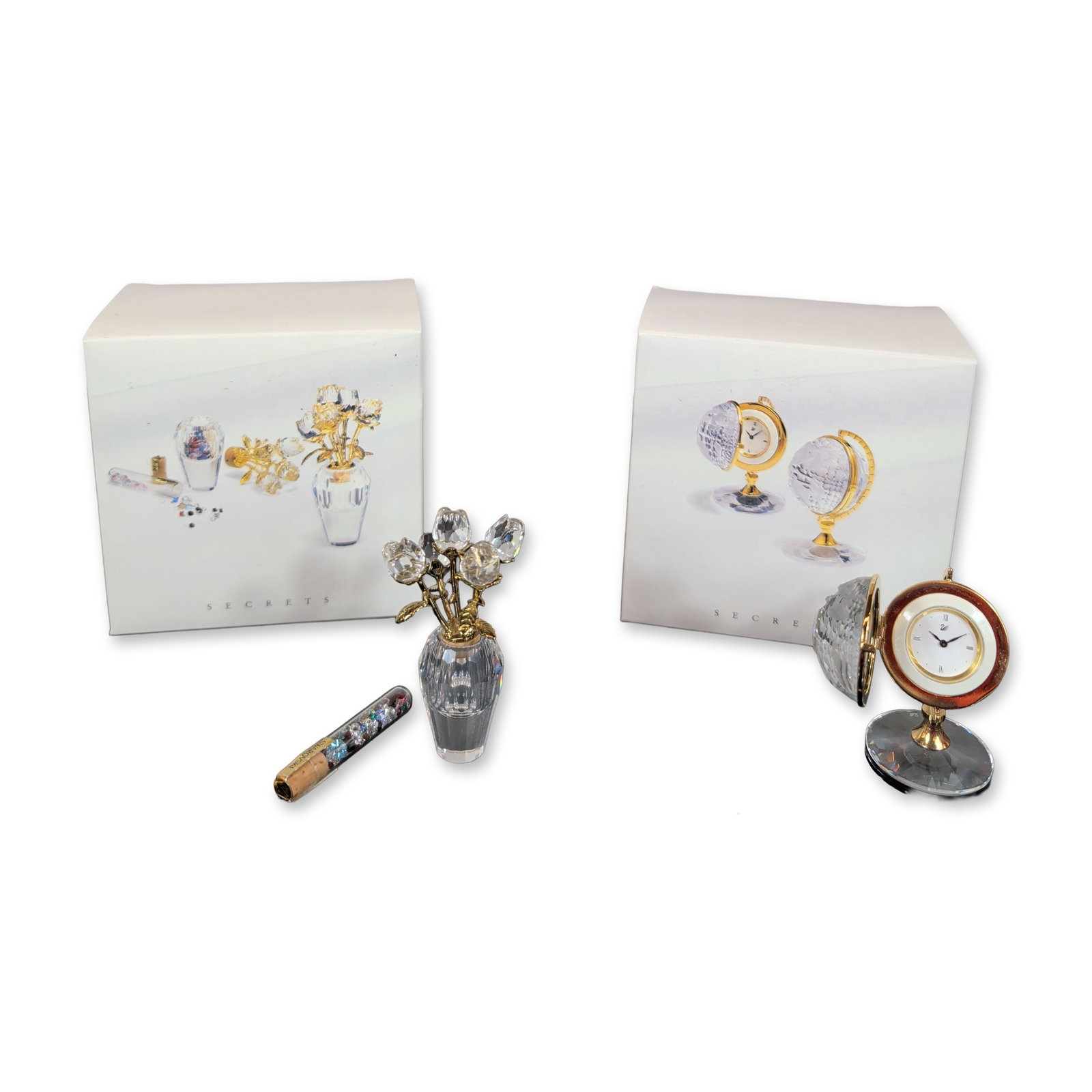 Two Swarovski Crystal Memories Secrets Collection Desk Clock Globe & Flower Vase with Crystal Vial: Two Swarovski miniature crystal figurines from the Secrets collection, featuring faceted lead crystal and gold-tone metal accents. The lot includes a globe-form desk clock with a hinged orb opening to