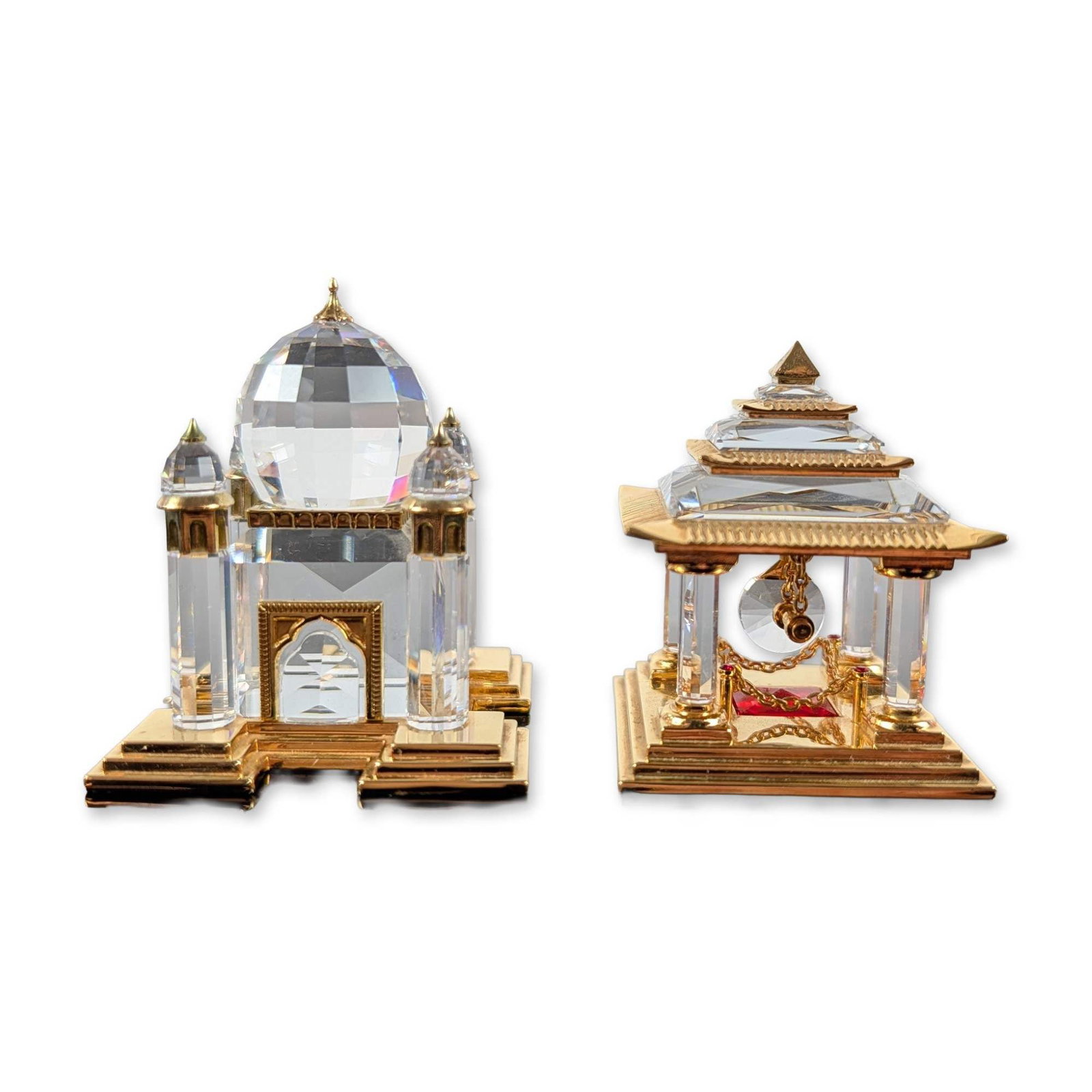 2pc Swarovski Crystal Taj Mahal and Japanese Temple Figurines: Swarovski. Two architectural figurines from the Crystal Memories Journeys collection in faceted lead crystal with gold-plated metal accents. The Taj Mahal model features four minarets surrounding a ce
