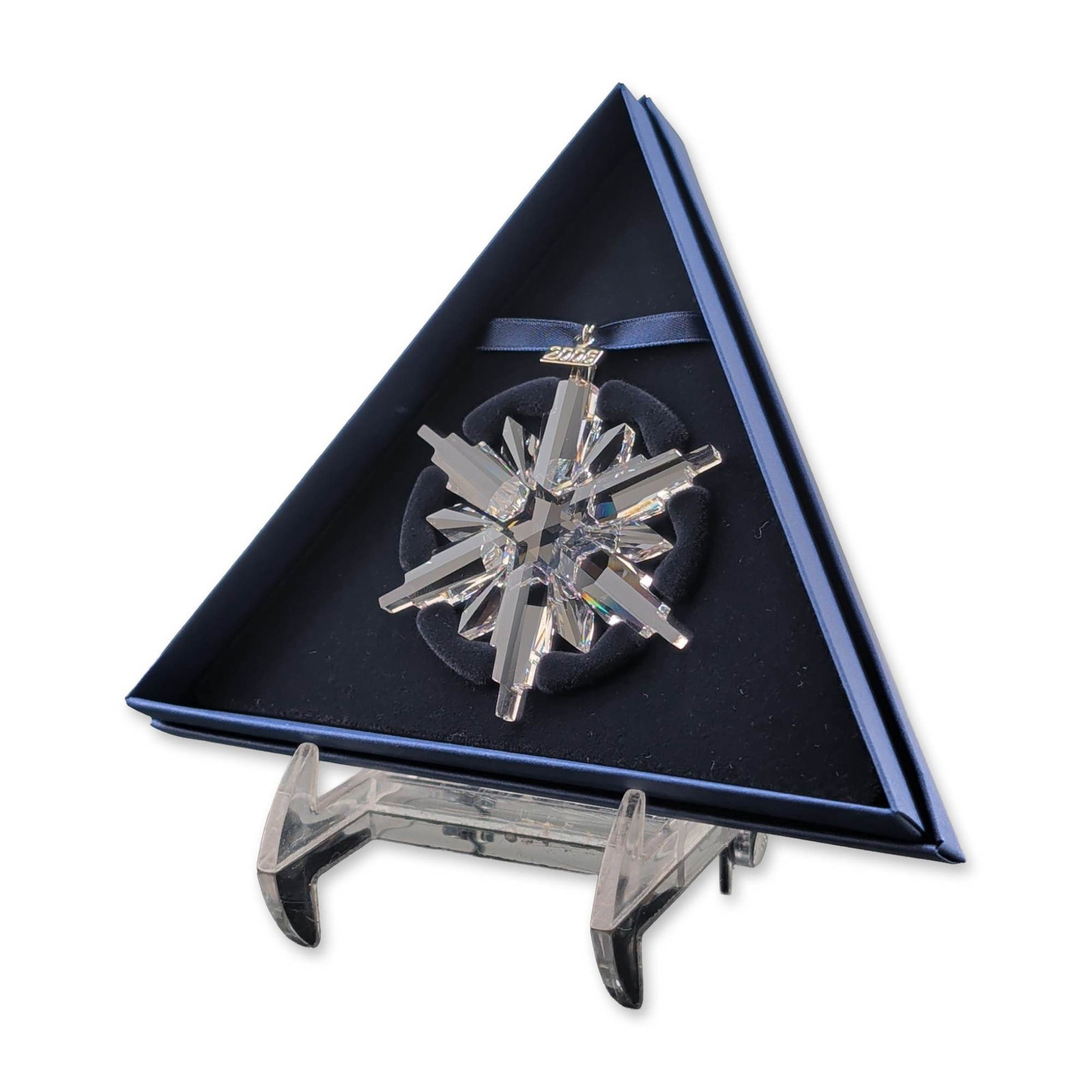 Swarovski 2006 Annual Edition Crystal Ornament: Swarovski 2006 Annual Edition Christmas ornament in faceted lead crystal, featuring a multi-point starburst design suspended from a dark blue ribbon. Includes a silver-toned metal hang tag dated 2006.