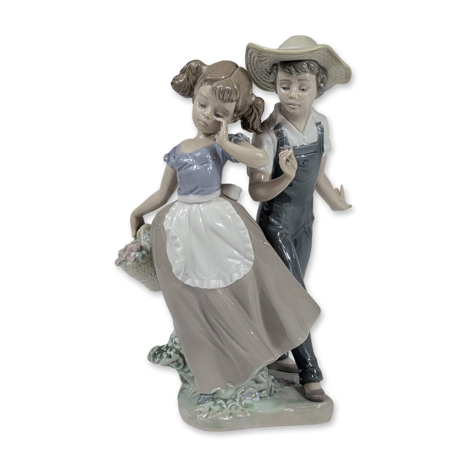 Lladro Spain Glazed Porcelain Love in Bloom Figurine: Lladro (Spain) glazed porcelain figurine titled Love in Bloom, model number 5292. The scene depicts a young boy in dark grey overalls, a white shirt, and a straw-style hat standing beside a young girl