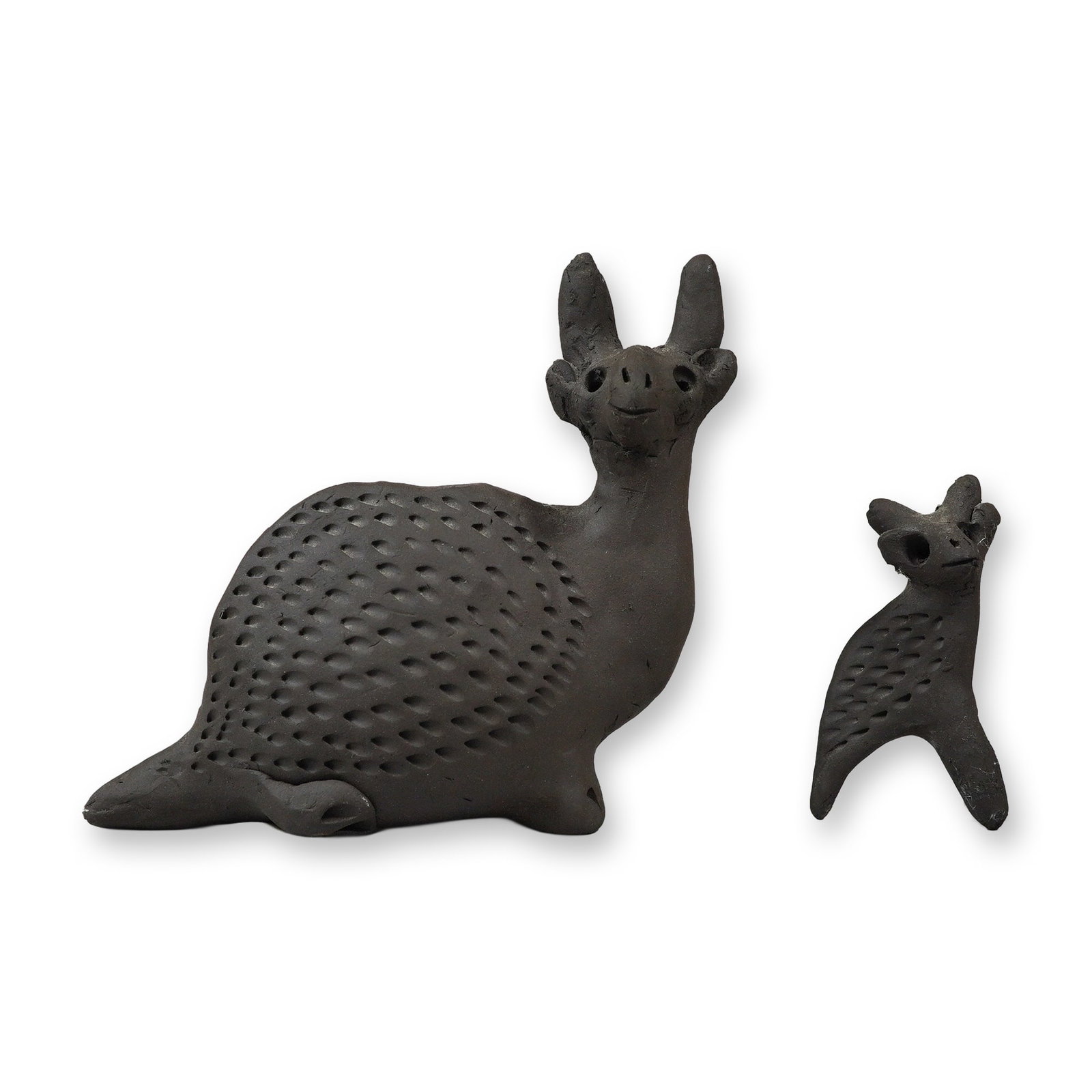 2pc Nicolas Family Barro Negro Clay Figurines, Oaxaca, Mexico: A set of two hand-molded black clay figurines from the Nicolas family of San Bartolo Coyotepec, Oaxaca, Mexico. These pieces are crafted from traditional barro negro ceramic with a matte finish. The l