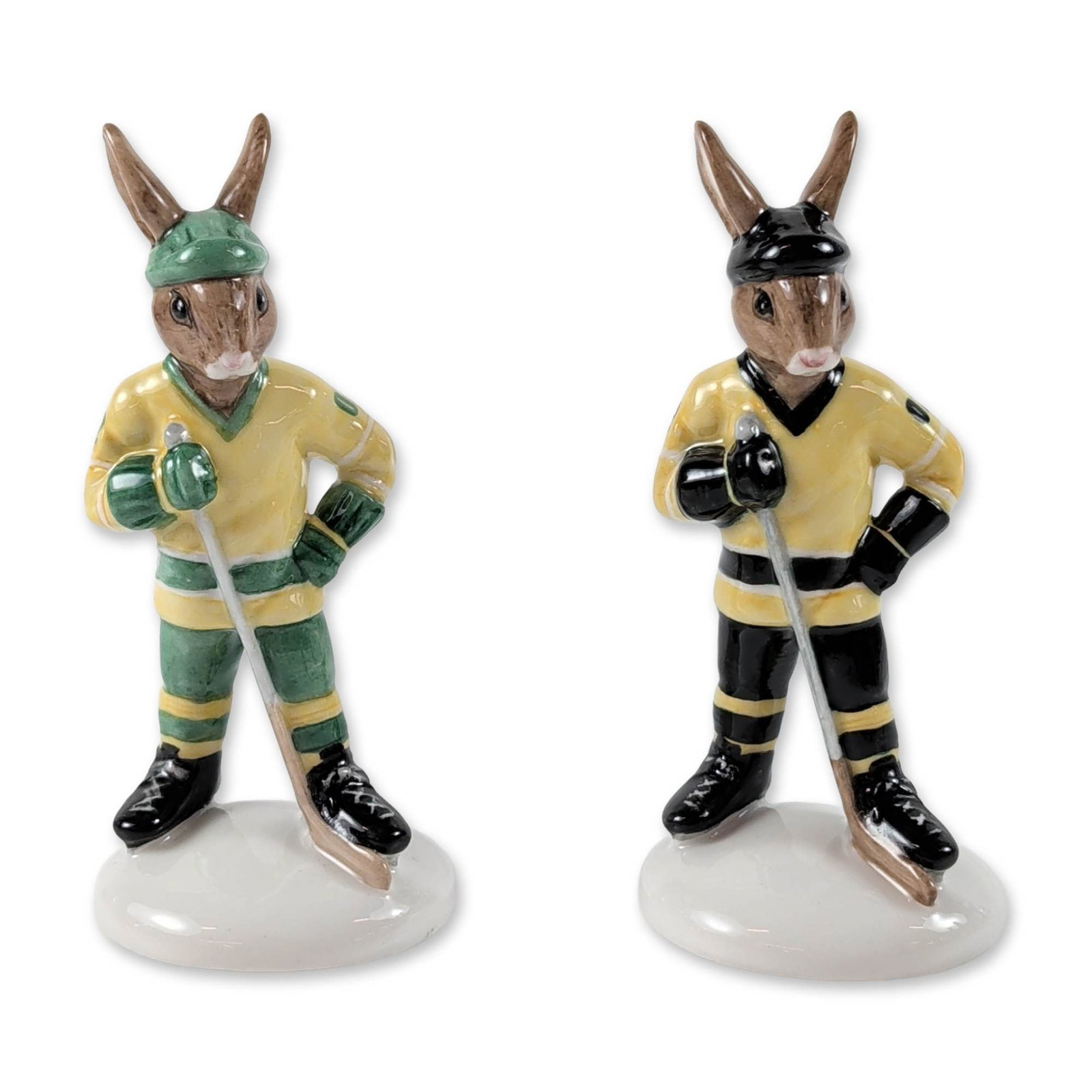 2pc Royal Doulton Ice Hockey Bunnykins Figurines: Royal Doulton (English, 2003). Pair of ceramic figurines from the Bunnykins collection titled Ice Hockey Bunnykins. The hand-decorated figures include one rabbit in a yellow and green uniform (DB 282)