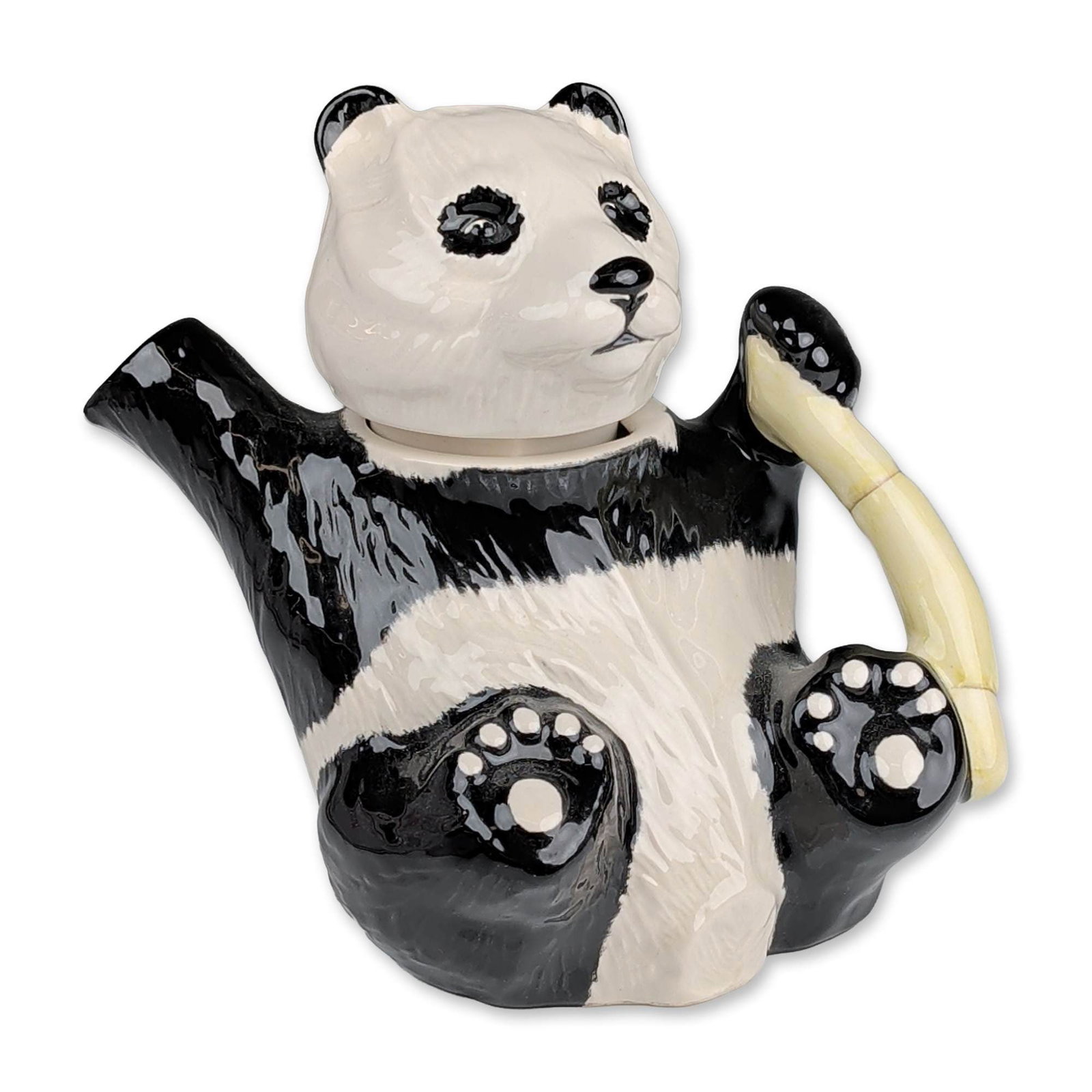 Beswick England Ceramic Panda Novelty Teapot: Beswick figural novelty teapot in the form of a reclining panda, crafted in glazed earthenware. The design features a black and white high-gloss glaze with molded fur texture, a front leg serving as t