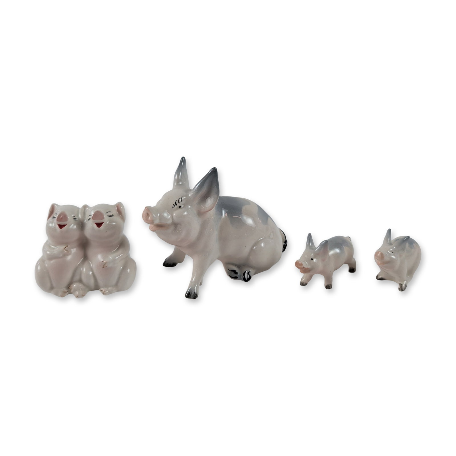 Group of Four Beswick Ceramic Pig Figurines: Beswick, England. Group of four glazed ceramic pig figurines, including one large standing sow with hand-painted gray patches and dark gray ears, a figural pair of seated piglets, and two individual s
