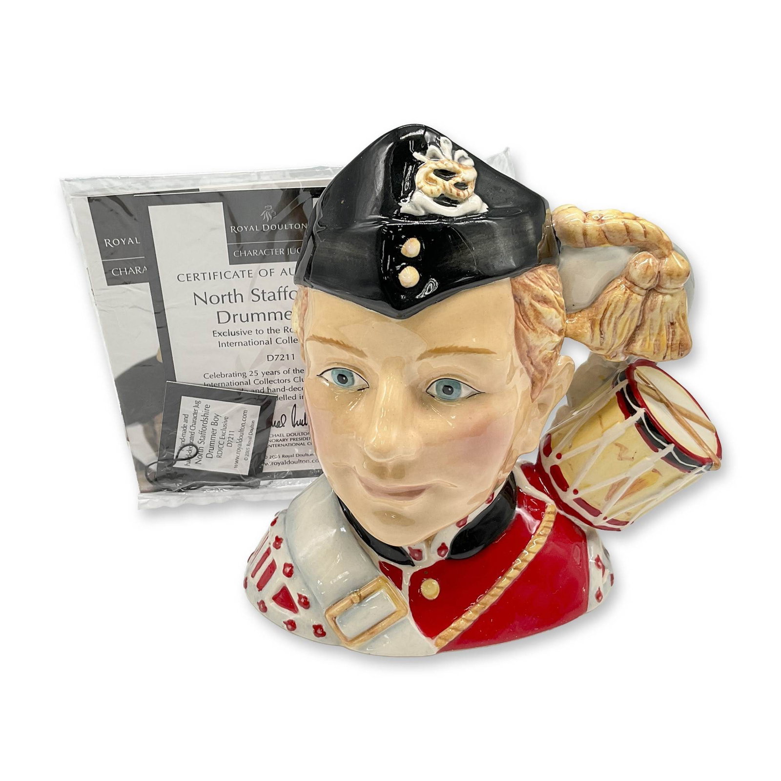 Drummer Boy D7211 - Small - Royal Doulton Character Jug: Celebrating 25 years of Collectors Club 1980-2005 with this colorful North Staffordshire figure. Coloration is red, yellow, black and red. Royal Doulton backstamp. This item has its original box: 8.25