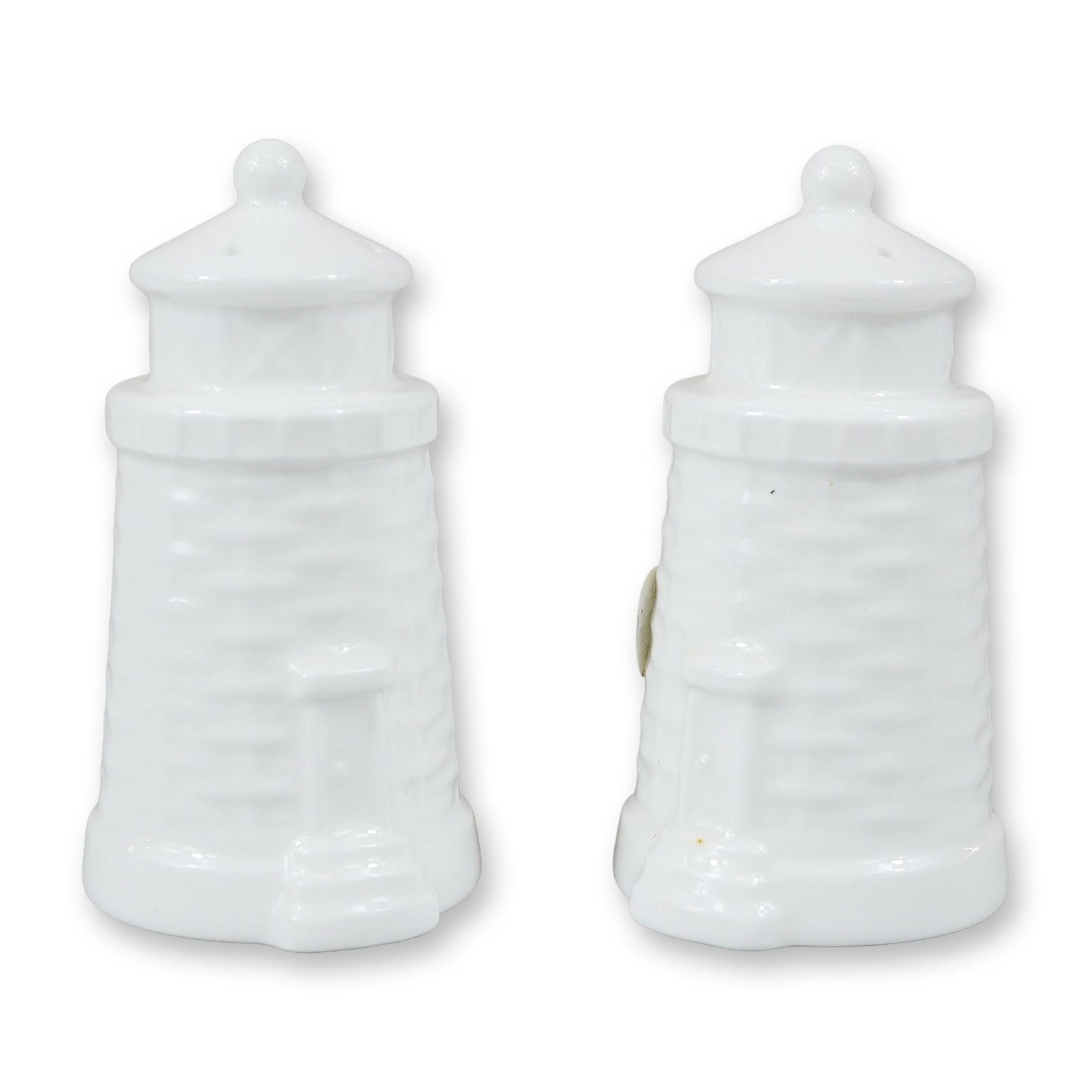 A Pair of Wedgwood Lighthouse Salt and Pepper Shakers in the Nantucket Pattern: A matching pair of white Wedgwood salt and pepper shakers molded in the form of lighthouses. The design features a basketweave textured base, reflecting the pattern's inspiration from Nantucket basket