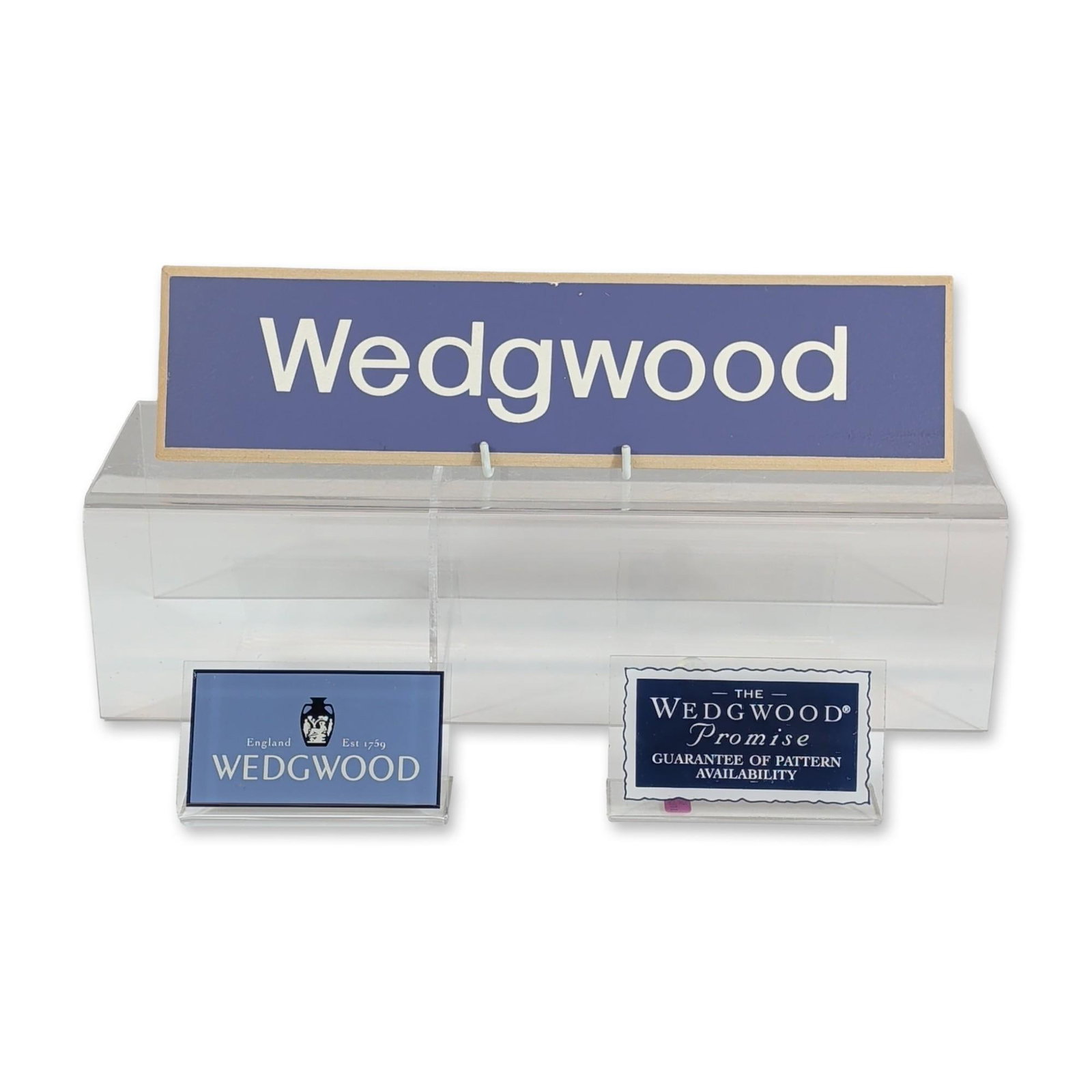 3pc Wedgwood Retail Countertop Advertising Display Signs: Wedgwood retail advertising display set, circa 1985. The set is housed in a custom clear acrylic holder designed for countertop use. It includes a large rectangular painted wood sign in a blue-lavende