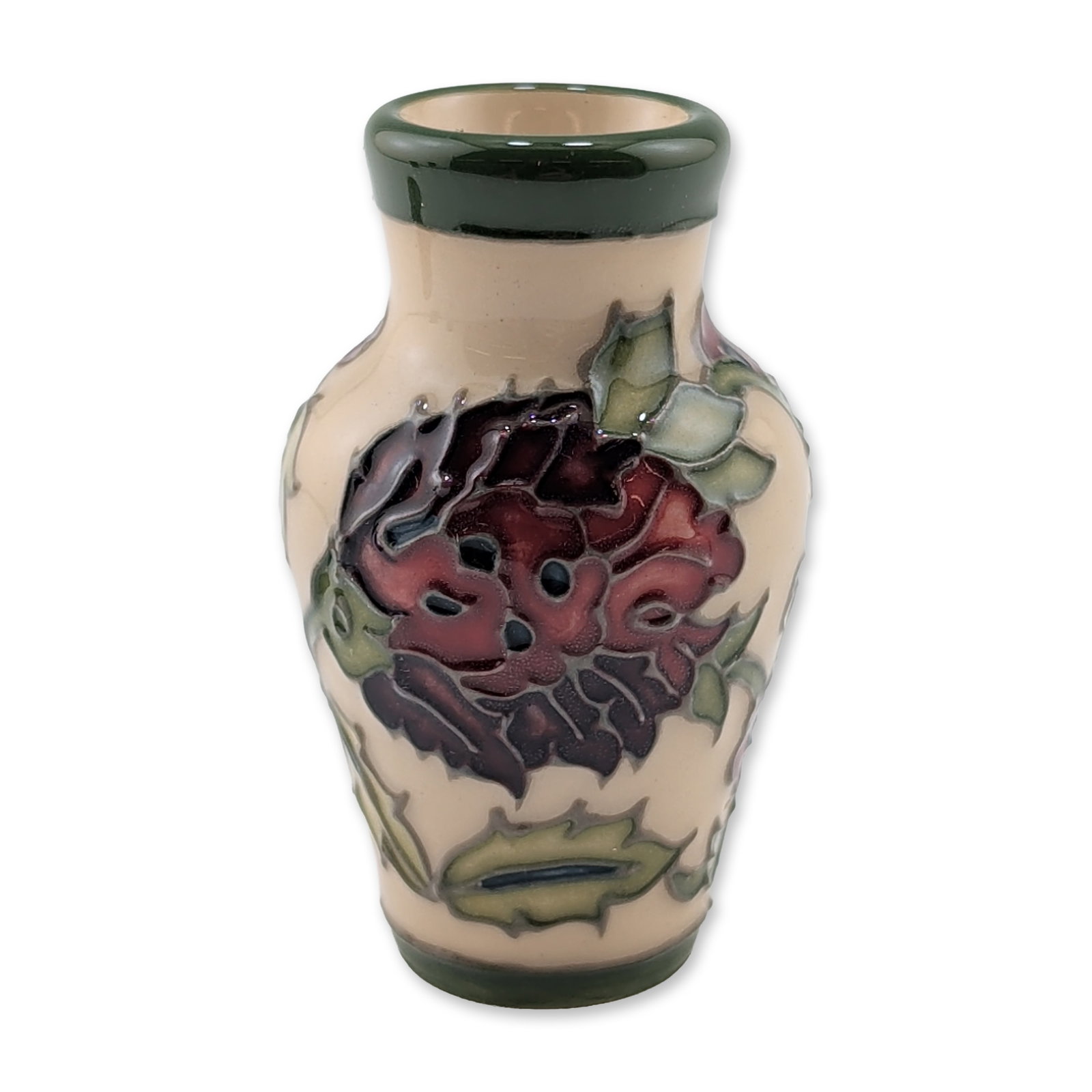 Moorcroft Pottery Miniature Vase, Pulsatilla: Miniature cabinet vase in earthenware, featuring hand-applied tube-lined floral decoration with a stylized deep red bloom and green foliate accents on a cream ground. Circular green factory stamp for