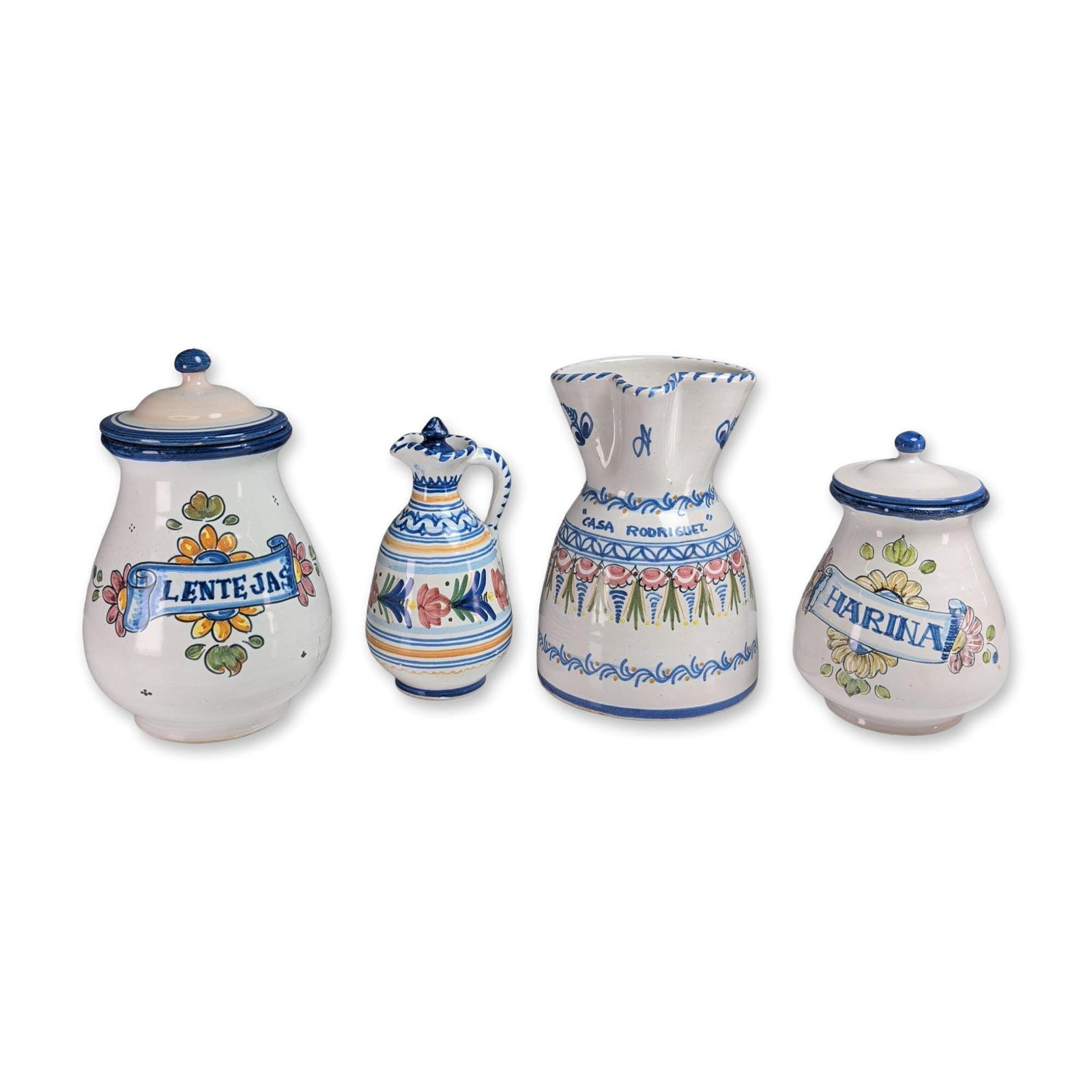 4pc Puente del Arzobispo Spanish Pottery Jars and Vessels: Puente del Arzobispo, Toledo, Spain. Four piece collection of hand painted earthenware pottery in the traditional Talavera style. The group includes two tapered lidded canisters, one large pitcher