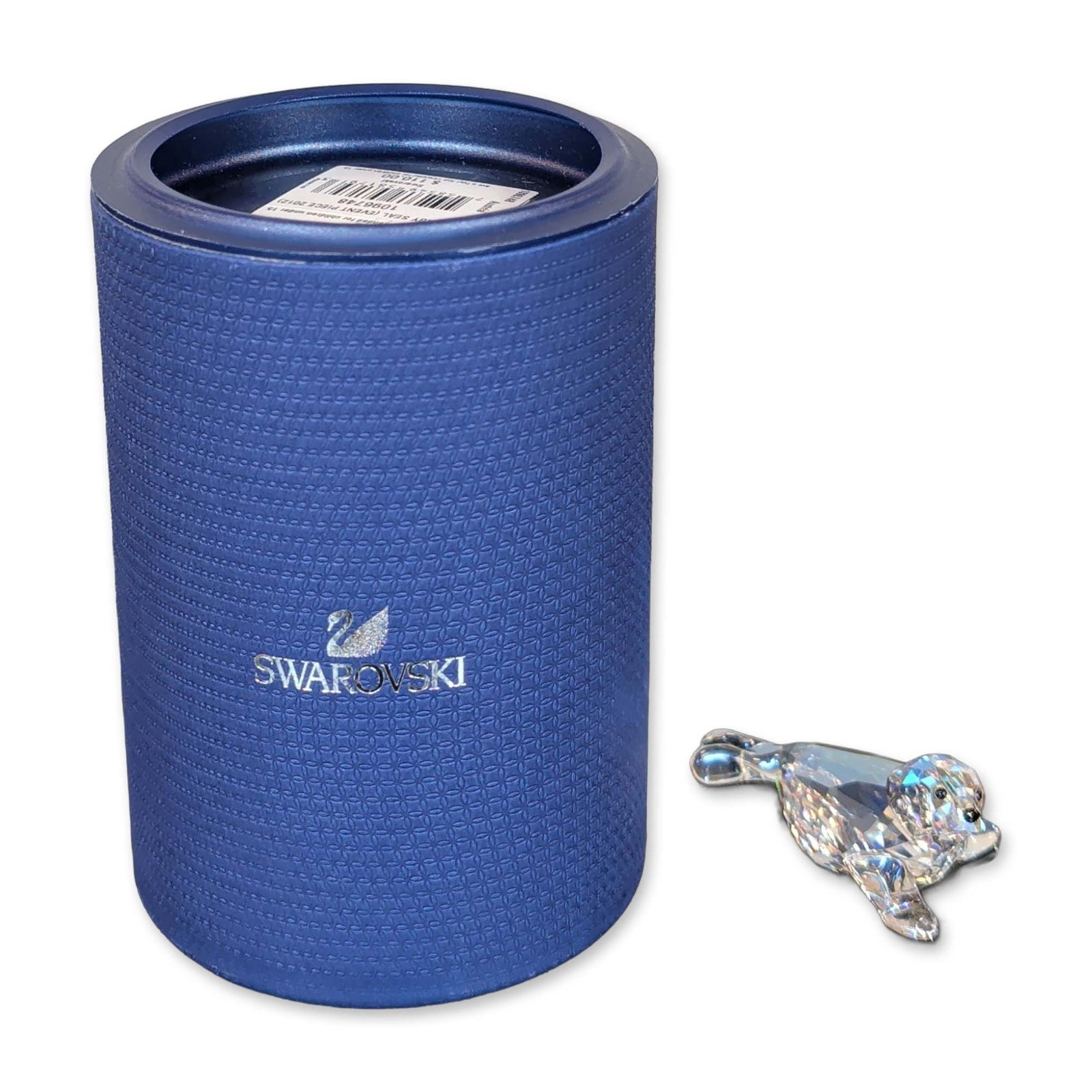 Swarovski Crystal Baby Seal Figurine 2012 Event Piece: Swarovski Baby seal figurine in faceted lead crystal featuring black crystal inset eyes., in a reclining pose with multiple light-reflecting facets. Bearing an acid-etched Swarovski swan logo to the t