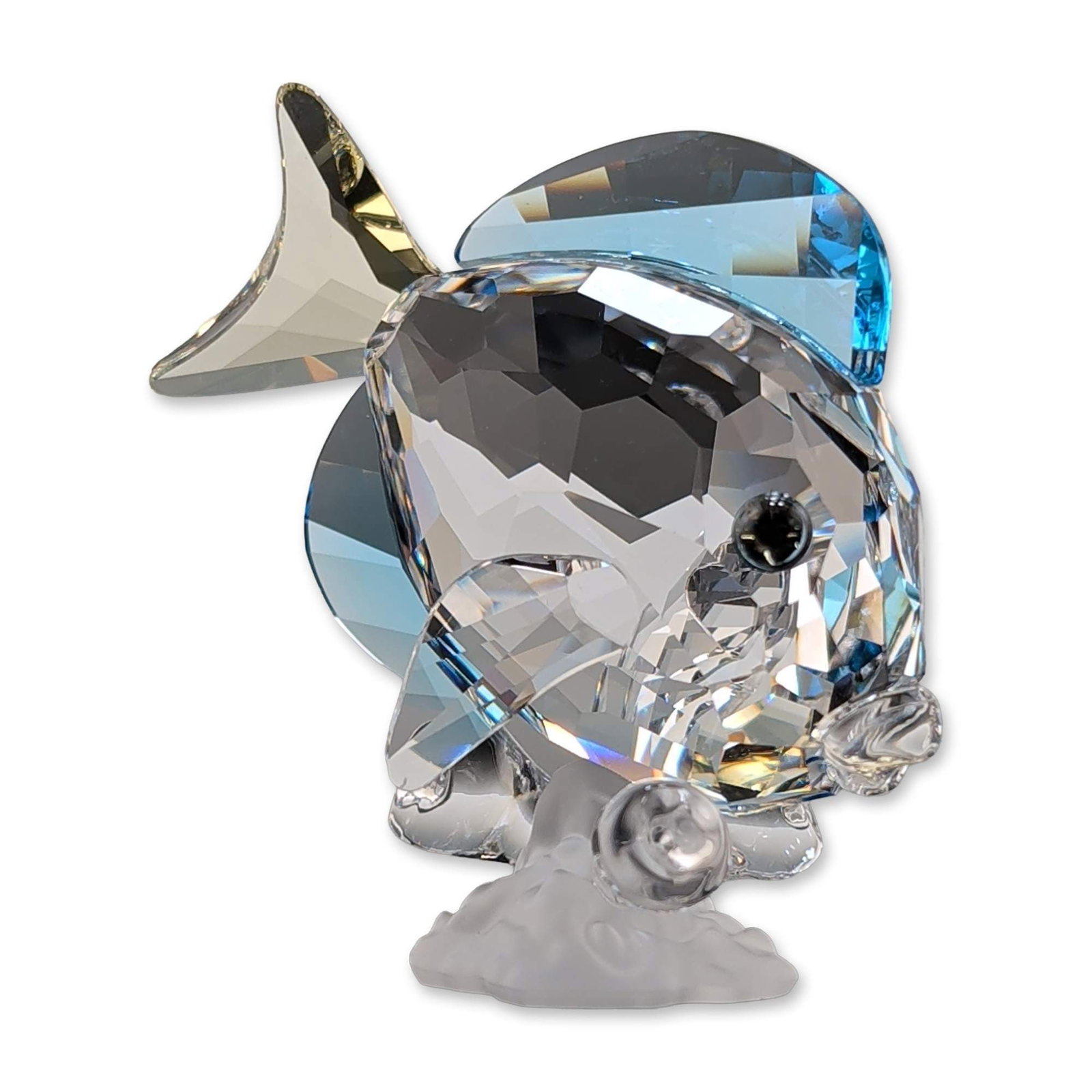 Swarovski Crystal Blue Tang Fish Figurine: Swarovski figurine depicting a Blue Tang fish from the Wonders of the Sea collection, model number 886180. The piece is constructed from faceted clear crystal with blue fins and a yellow tail, mounted