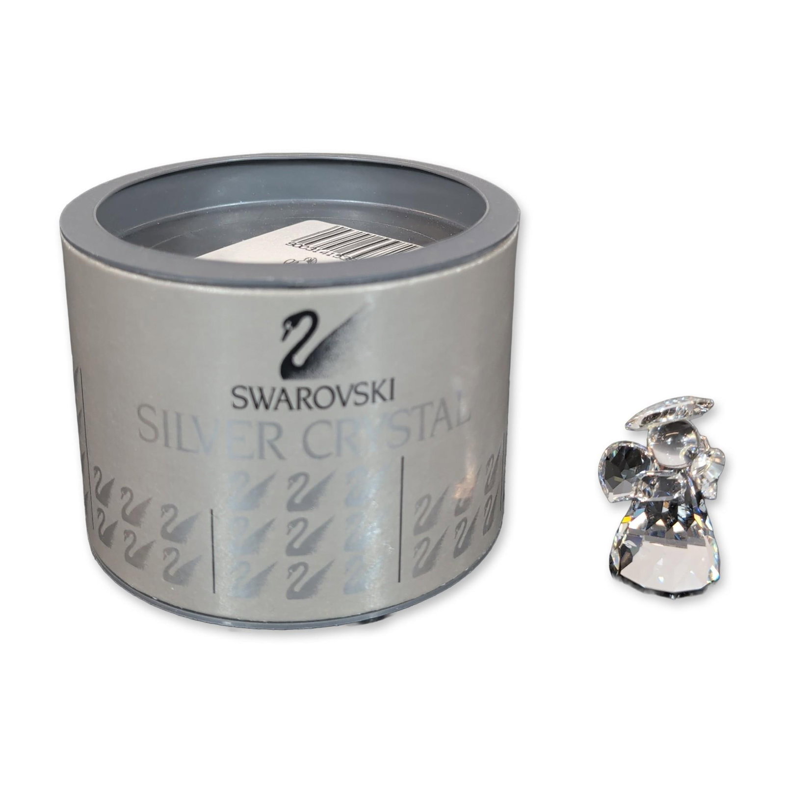 Swarovski Crystal Nativity Scene Angel Figurine: Swarovski Crystal Nativity Scene featuring an angel figurine. Item includes its original cylindrical silver-toned presentation box with a black swan logo and repeating logo pattern. The base of the